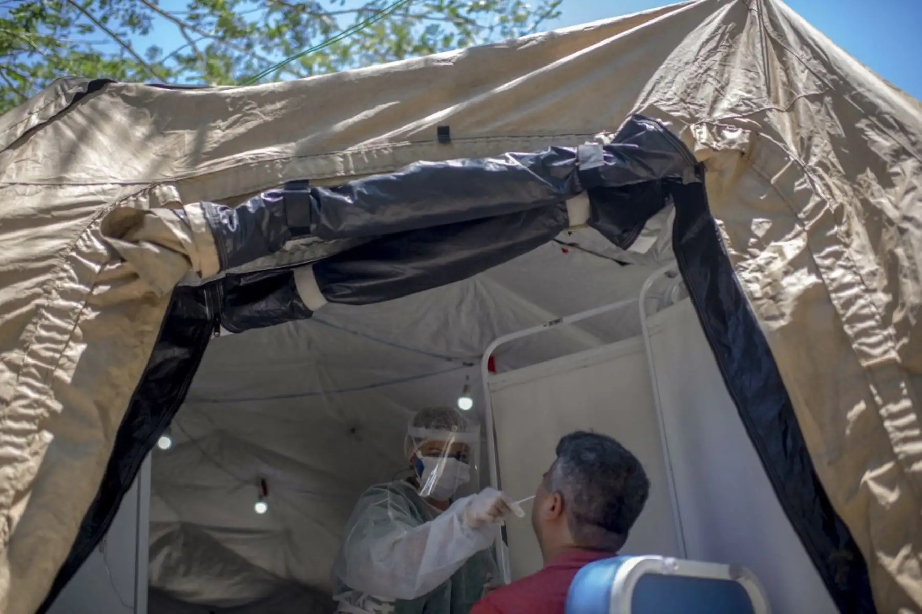 Un trabajador de la salud realiza una prueba de PCR a un hombre para detectar el coronavirus COVID-19 en una unidad de salud pública. Foto: AFP