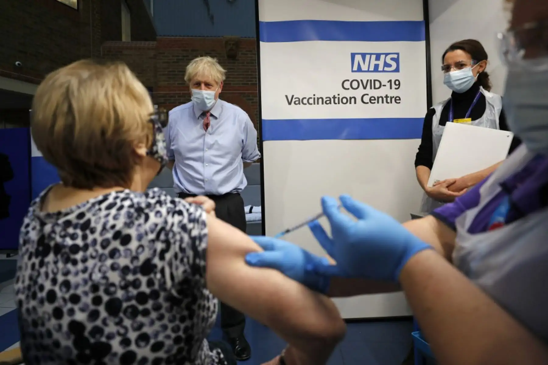 El primer ministro británico, Boris Johnson, observa cómo la enfermera Rebecca Cathersides administra la vacuna Pfizer-BioNTech COVID-19 a Lyn Wheeler en el Guy