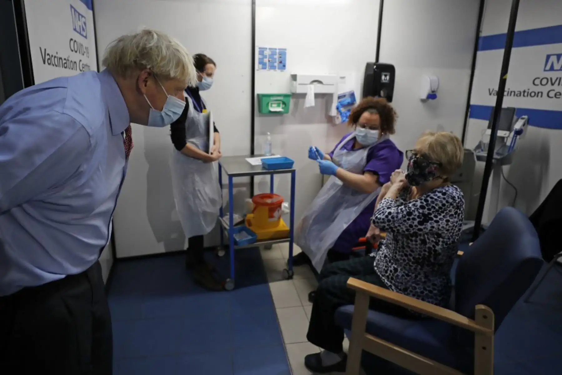 El primer ministro británico, Boris Johnson, habla con Lyn Wheeler antes de que la enfermera Rebecca Cathersides le administre la vacuna Pfizer-BioNTech COVID-19 en el Guy