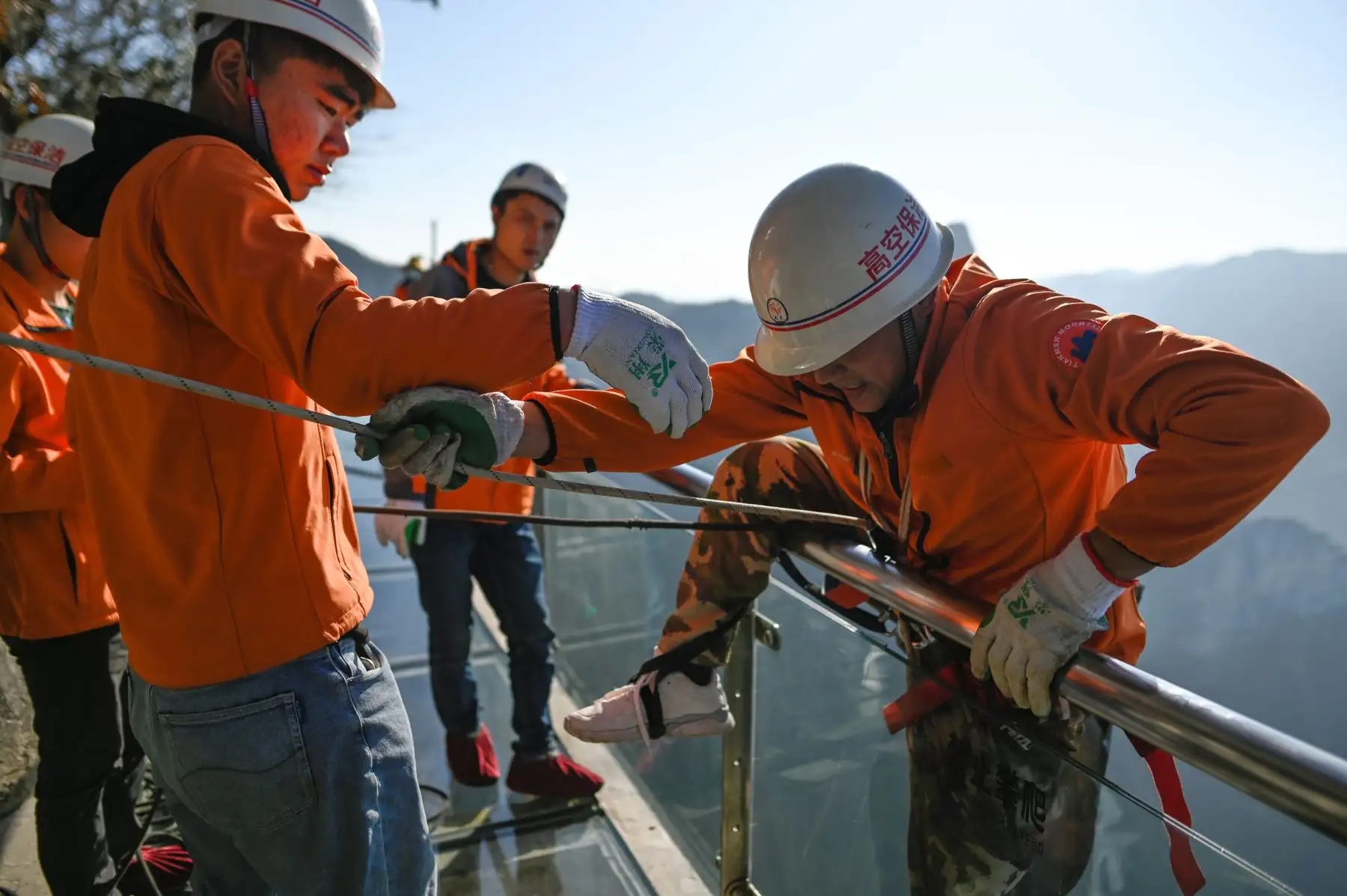 Un limpiador se prepara para hacer rappel desde una pasarela de vidrio en la montaña Tianmen, en Zhangjiajie, China. Foto: AFP