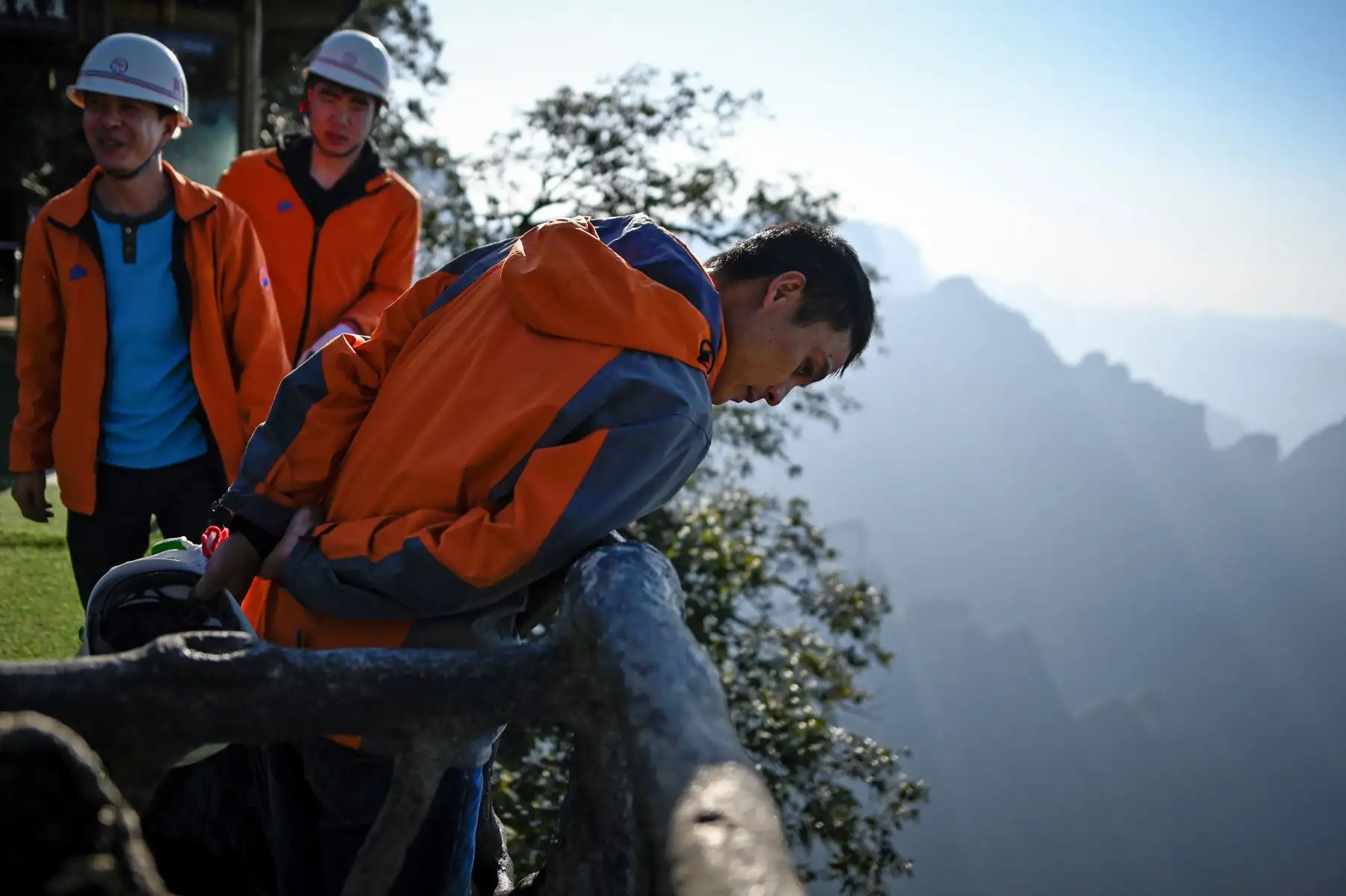 Un grupo de limpiadores revisan el área después de recolectar basura en la montaña Tianmen, en Zhangjiajie, China. Foto: AFP