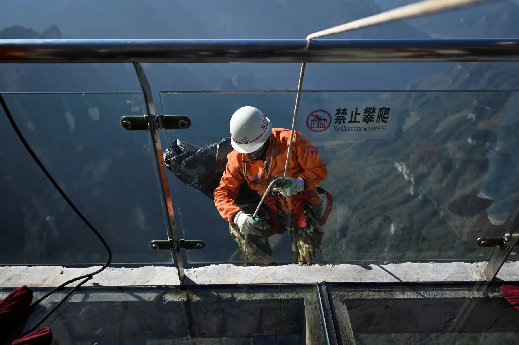 Un limpiador se prepara para descender a recolectar la basura arrojada por los malos turistas en montaña Tianmen, en Zhangjiajie, China. Foto: AFP