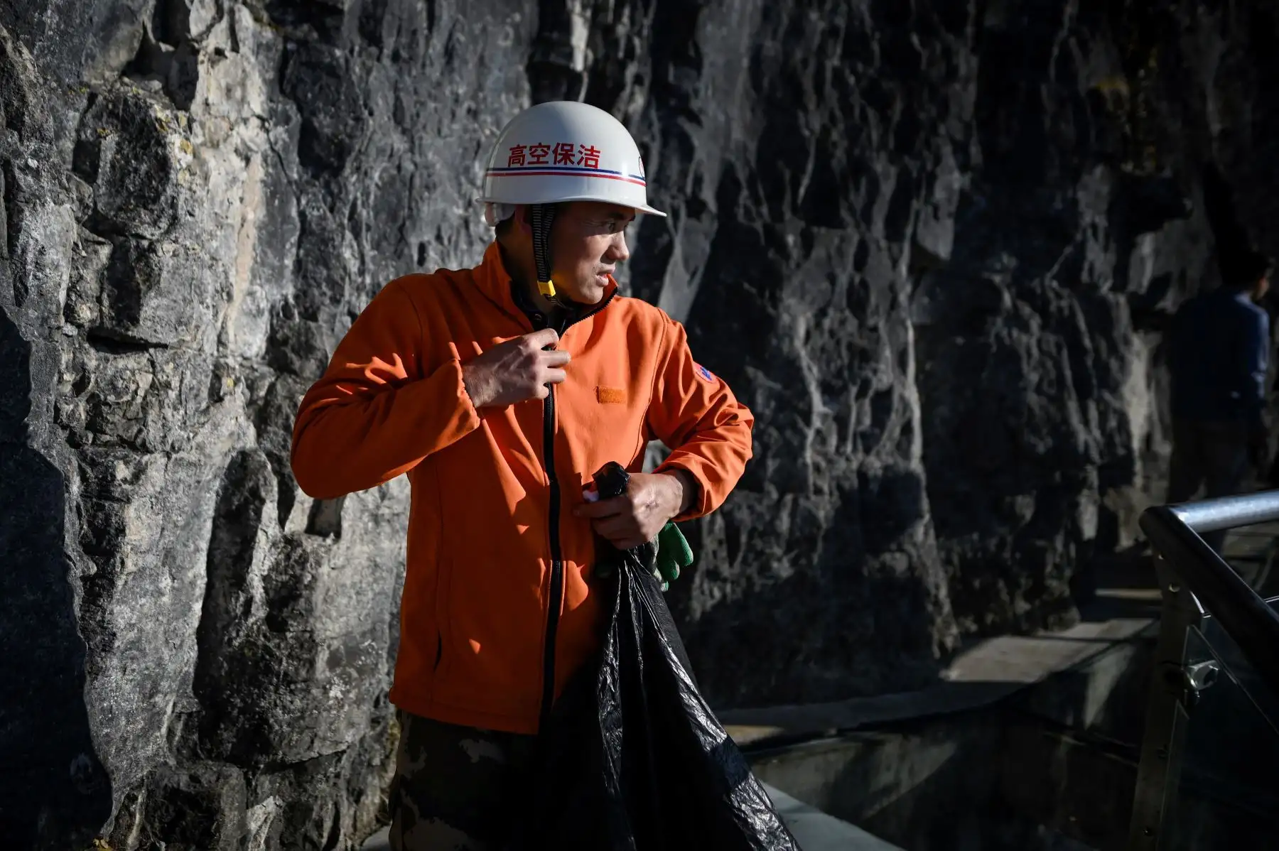 Un limpiador se alista para descender y realizar de labor en la montaña Tianmen, en Zhangjiajie, China. Foto: AFP