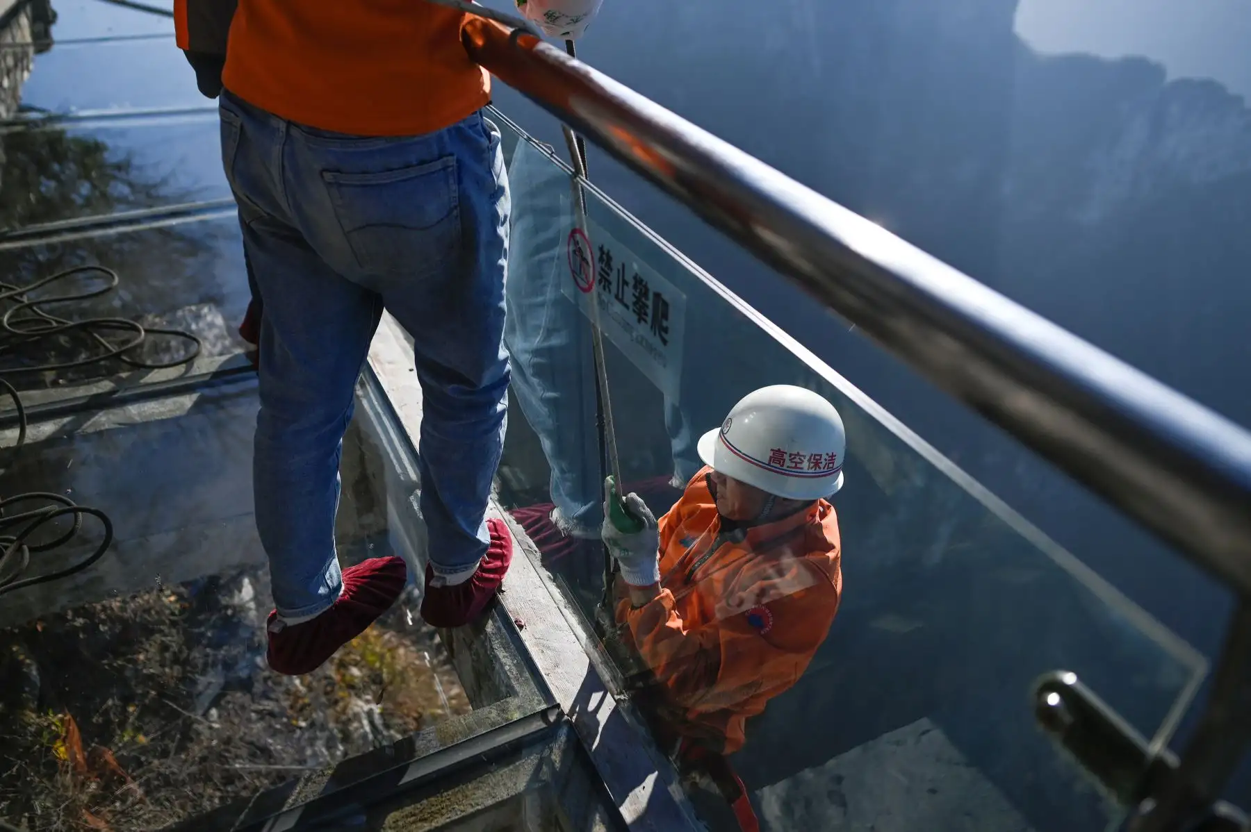 Un limpiador desciende haciendo rappel para recolectar basura arrojada por malos turistas en la montaña Tianmen, en Zhangjiajie, China. Foto: AFP