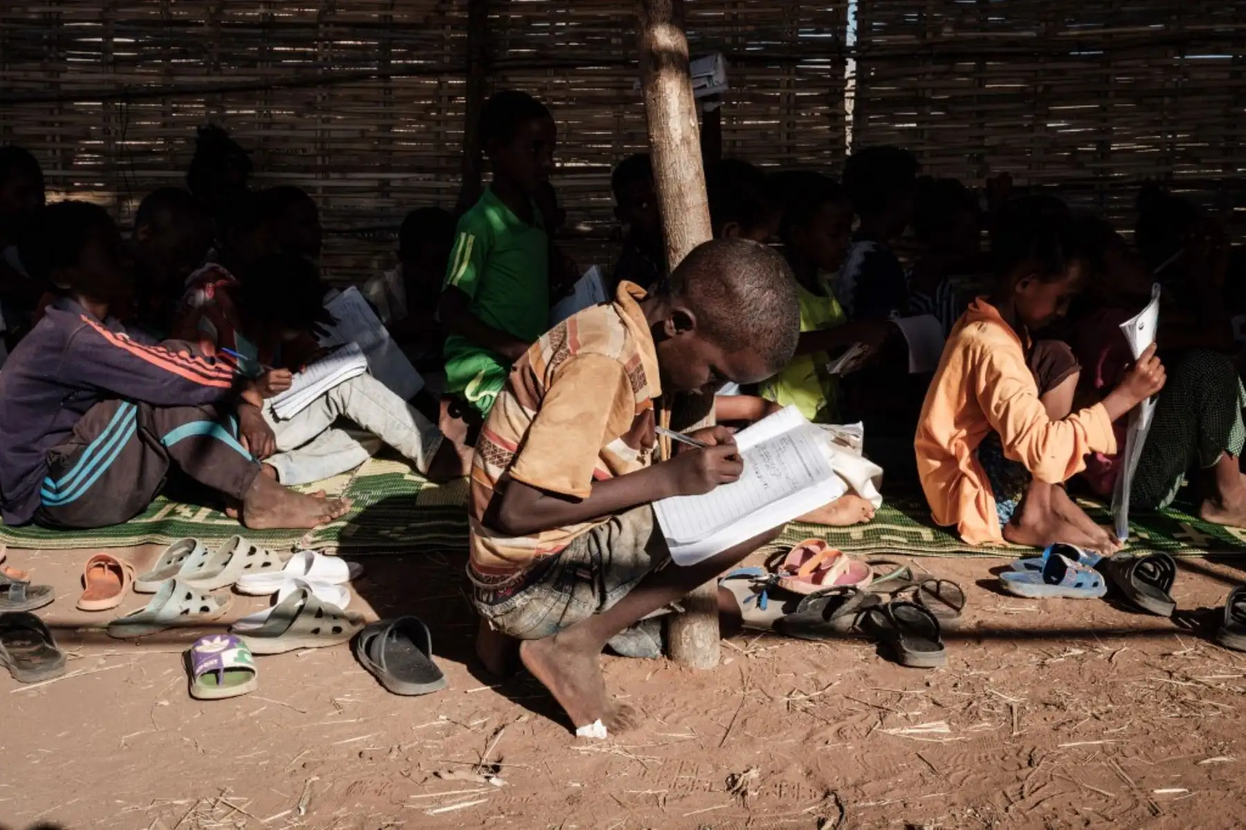 Los refugiados etíopes de cuarto grado que huyeron del conflicto de Tigray asisten a clases en un aula improvisada establecida por el Consejo Noruego para los Refugiados (NRC) en el campamento de refugiados de Um Raquba en Gedaref, en el este de Sudán. Foto: AFP