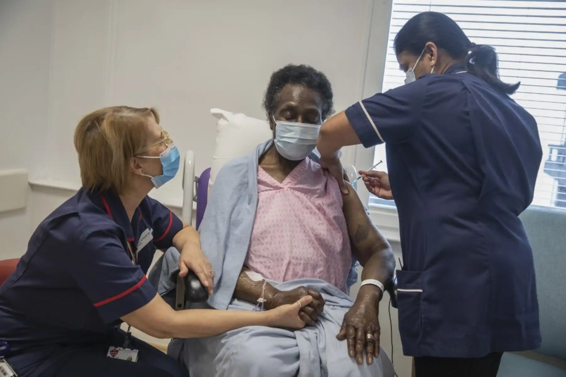 La enfermera principal Dilhani Somaweera (R) administra la vacuna Pfizer-BioNTech Covid-19 a Josephine Faleye (C), de 80 años, en el hospital Royal Free de Londres el 8 de diciembre de 2020 al inicio del programa de vacunación más grande del Reino Unido. Foto: AFP