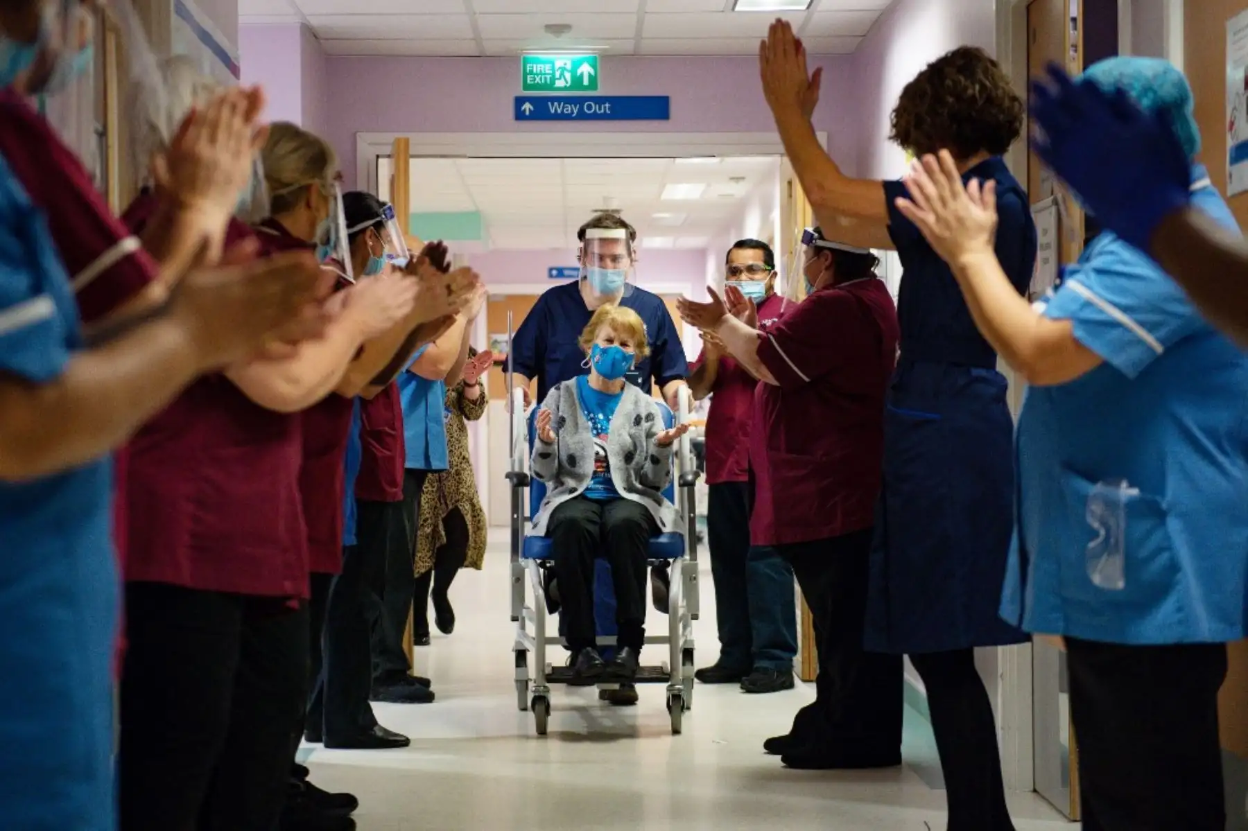 Margaret Keenan, de 90 años, es aplaudida por el personal cuando regresa a su sala después de convertirse en la primera persona en recibir la vacuna Pfizer-BioNtech Covid-19 en el Hospital Universitario de Coventry, en el centro de Inglaterra. Foto: AFP