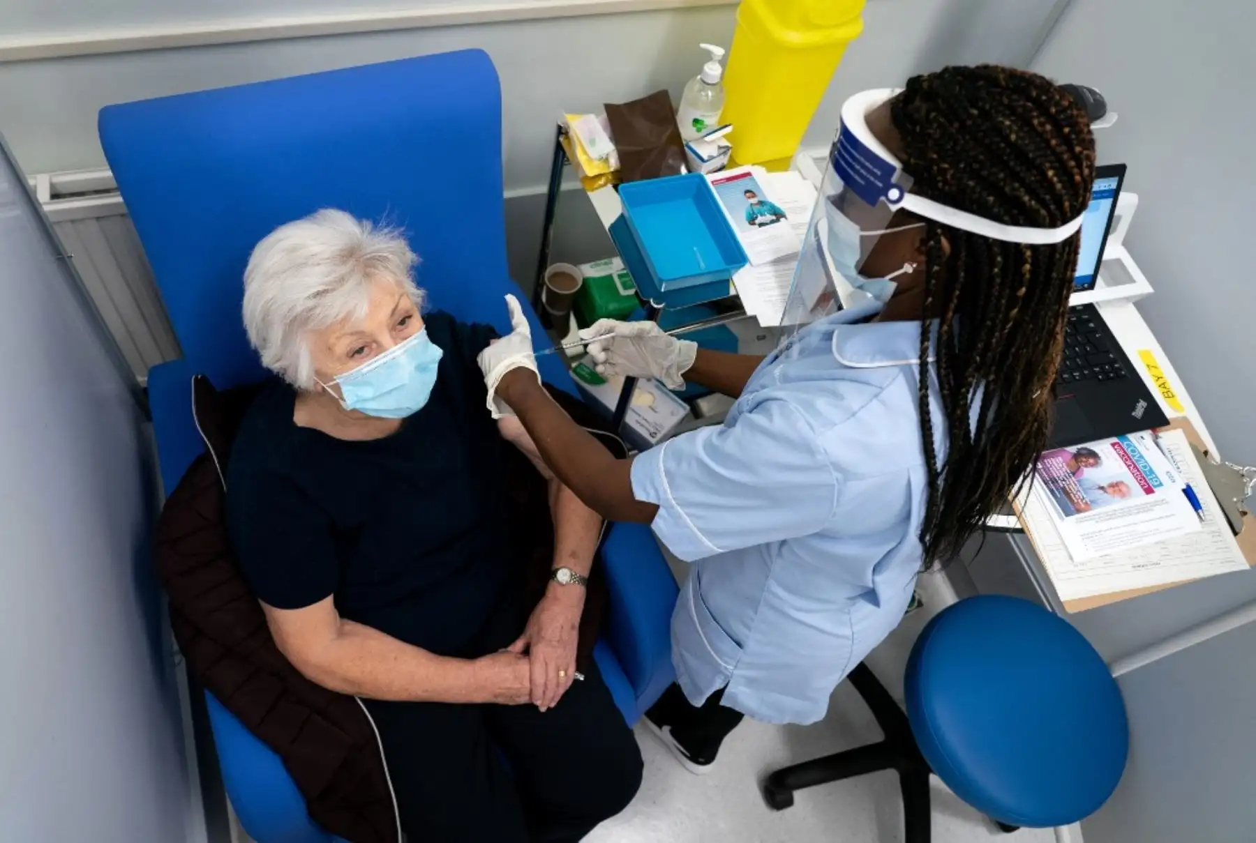 Anne Irene (izquierda) reacciona cuando recibe una dosis de la vacuna Pfizer / BioNTech Covid-19 en el Hospital de la Universidad de Croydon en el sur de Londres. Foto: AFP
