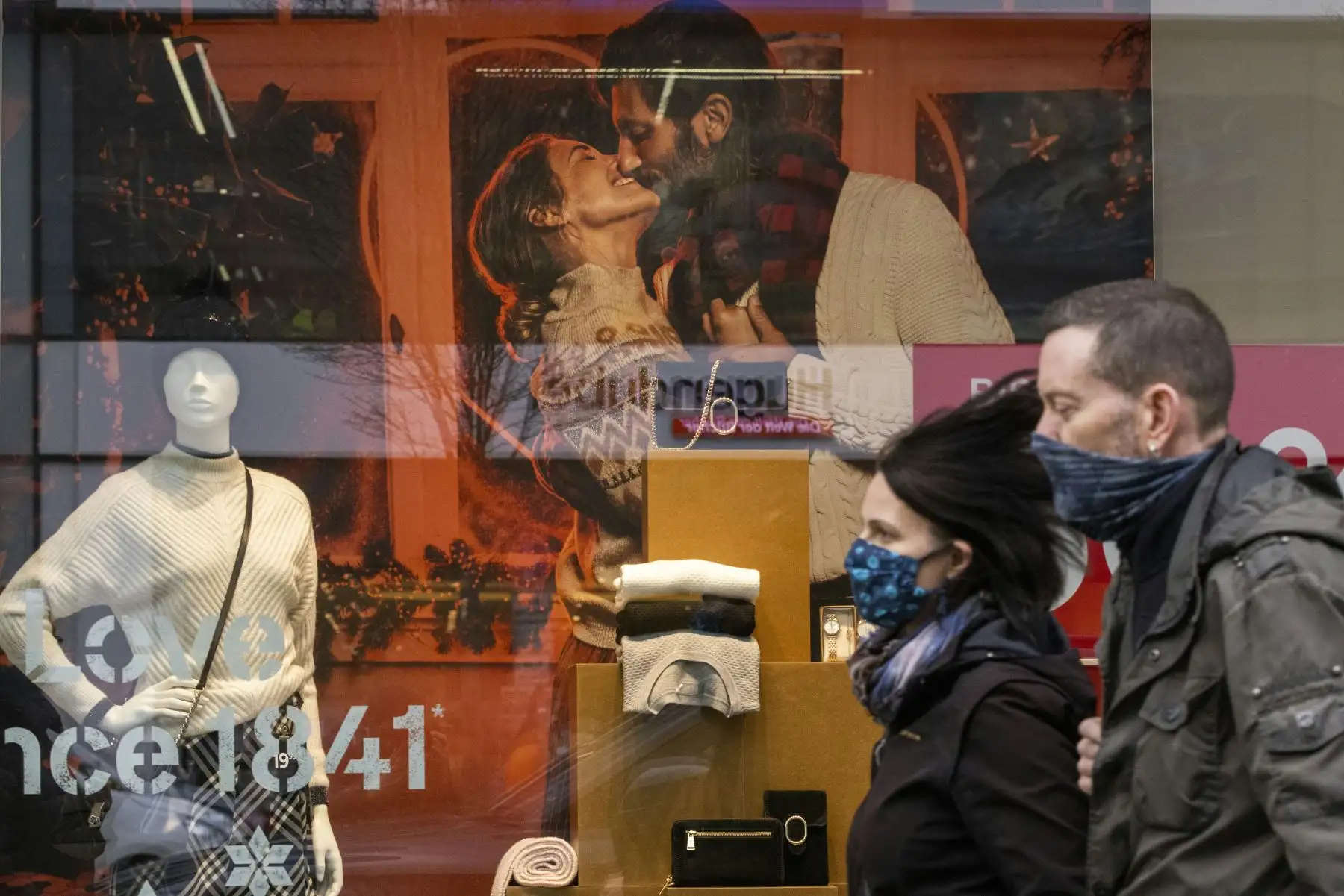 Los compradores navideños pasan junto a los carteles de venta en una tienda departamental en la calle Schlossstrasse en Berlín. Foto: AFP