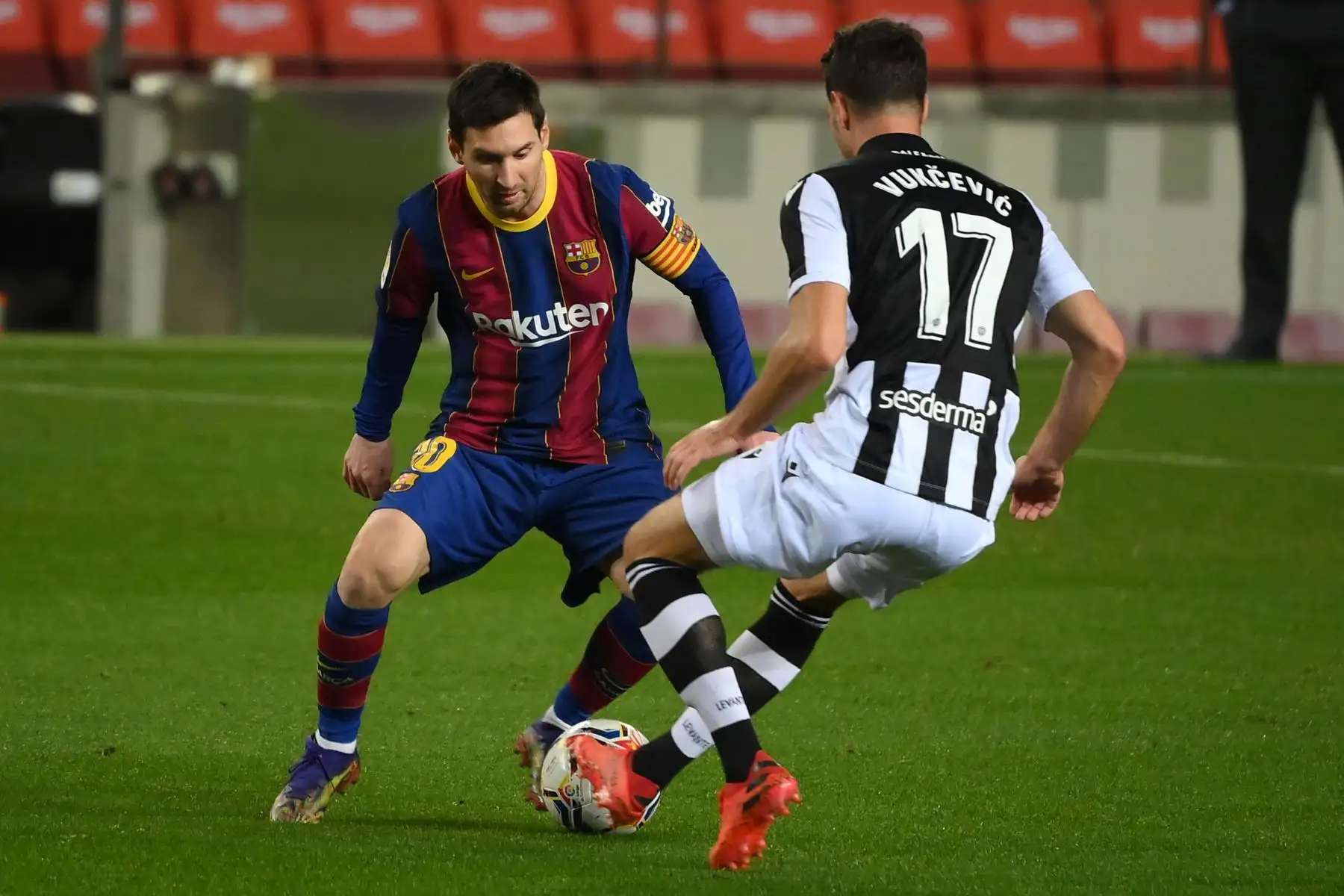 El centrocampista montenegrino del Levante Nikola Vukcevic desafía al delantero argentino del Barcelona Lionel Messi durante el partido de fútbol de la liga española. Foto: AFP