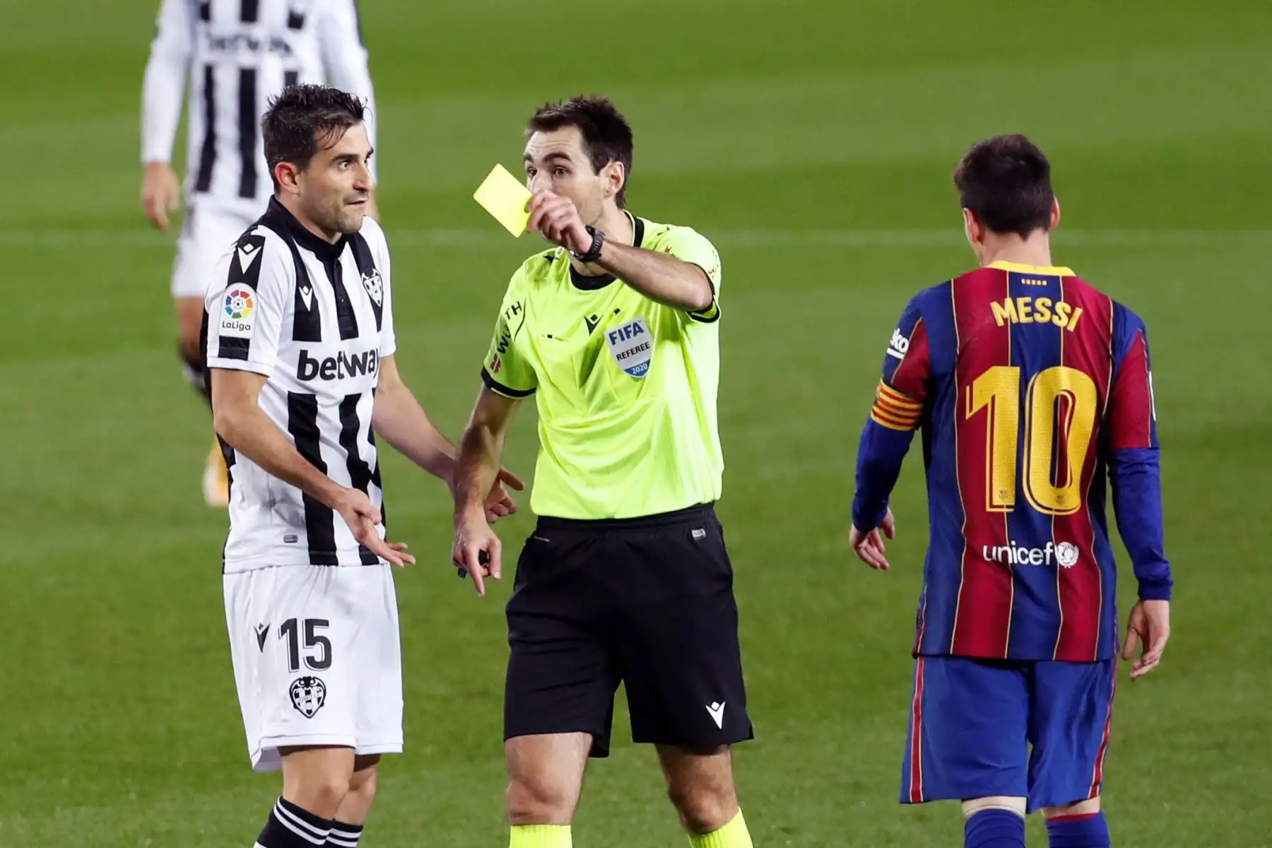 El árbitro muestra tarjeta amarilla al defensa del Levante, Sergio Postigo, tras una falta cometida sobre el delantero argentino del FC Barcelona, ​​Leo Messi, durante el partido por la Liga española. Foto: EFE