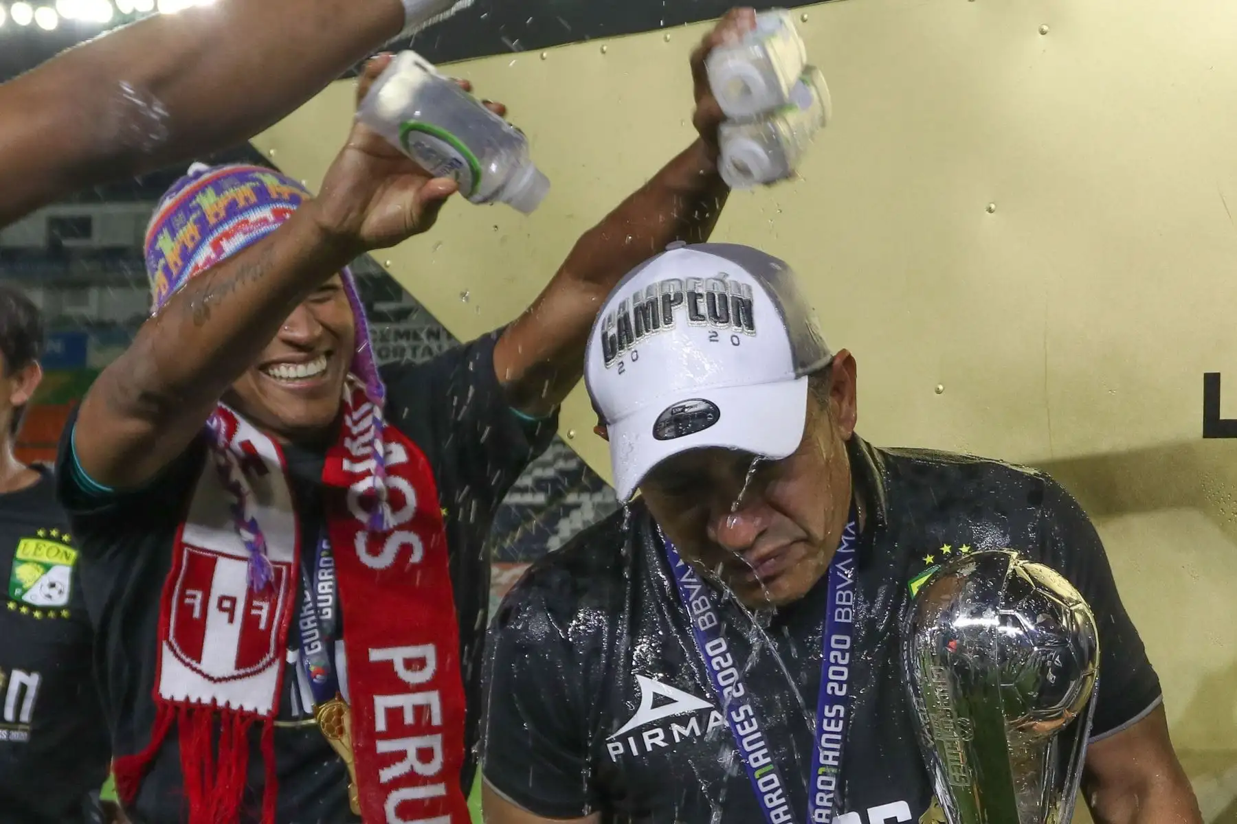 Pedro Aquino le tira cerveza al director técnico del León, Marcos Ambriz, como parte de las celebraciones tras haberse adjudicado el campeonato del fútbol mexicano al vencer a Pumas de la UNAMeste domingo, en el estadio León, del estado de Guanajuato, donde se juega la final del torneo Guard1anes del torneo apertura del fútbol mexicano a puerta cerrada debido a la contingencia sanitaria. 

Foto:EFE