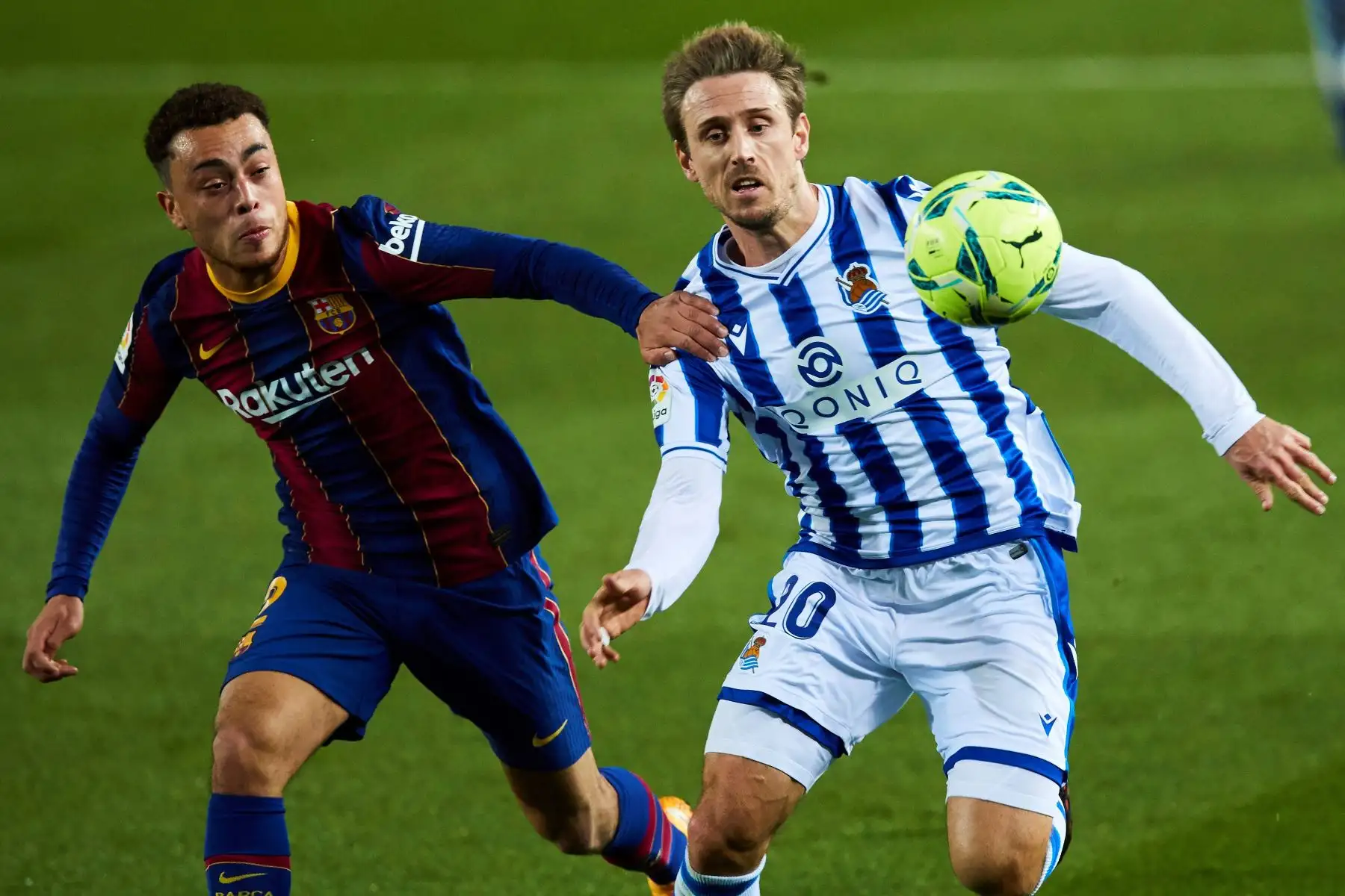 El defensa del FC Barcelona Sergiño Dest pelea la posesión del balón con el defensa de la Real Sociedad Nacho Monreal durante un encuentro correspondiente a la decimonovena jornada de la LaLiga Santander. Foto: EFE
