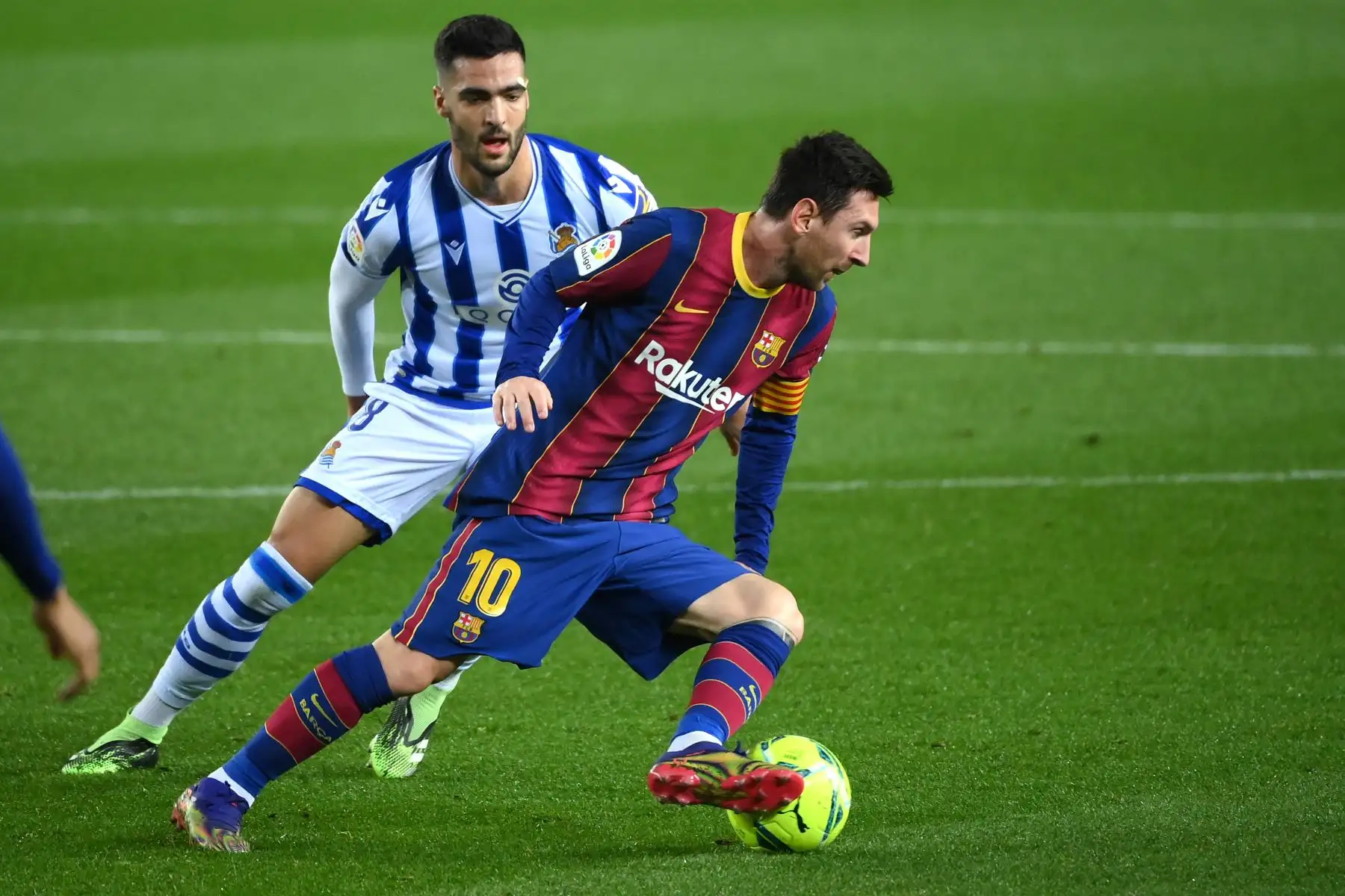 El delantero argentino del Barcelona Lionel Messi compite con el mediocampista español de la Real Sociedad Mikel Merino durante el partido de fútbol de la liga española. Foto: AFP