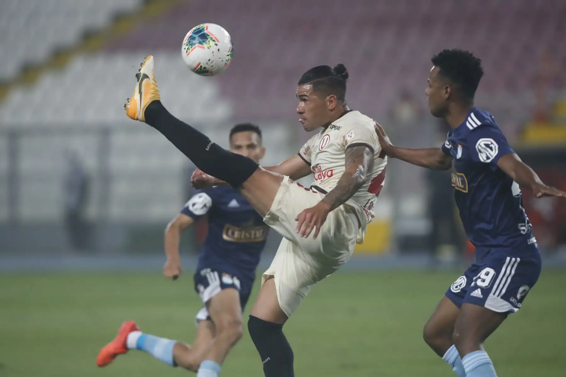 El futbolista Do Santos de  Universitario , disputa la pelota con el jugador de  Sporting Cristal, durante el partido por la el título nacional de la  Liga 1 del Torneo Apertura 2020, en el Estadio Nacional.  
Foto: Liga 1 FPF El futbolista Do Santos de  Universitario , disputa la pelota con el jugador de  Sporting Cristal, durante el partido por la el título nacional de la  Liga 1 del Torneo Apertura 2020, en el Estadio Nacional.  
Foto: Liga 1 FPF