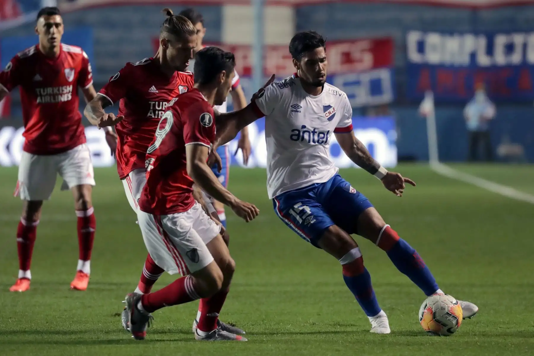 El Nacional Ayrton Cougo de Uruguay está marcado por jugadores del River Plate de Argentina durante su partido de fútbol de cuartos de final de la Copa Libertadores a puerta cerrada en el estadio Gran Parque Central de Montevideo.
Foto: AFP