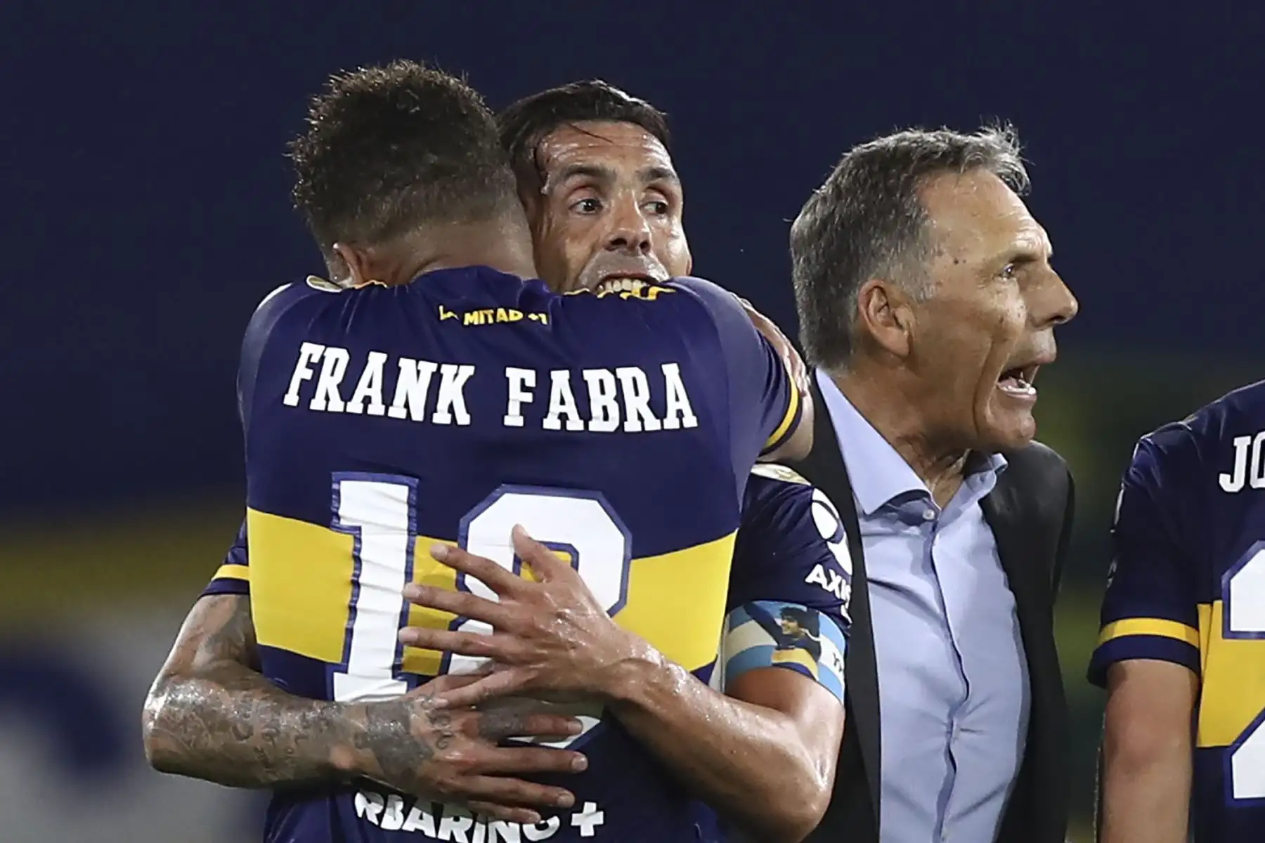 Carlos Tevez  de Boca Juniors y su compañero de equipo colombiano Frank Fabra celebran junto al entrenador Miguel Angel Russo tras vencer 2-0 al Racing Club para llegar a las semifinales de la Copa Libertadores, al finalizar su partido de cuartos de final argentino en La Bombonera
Foto: AFP