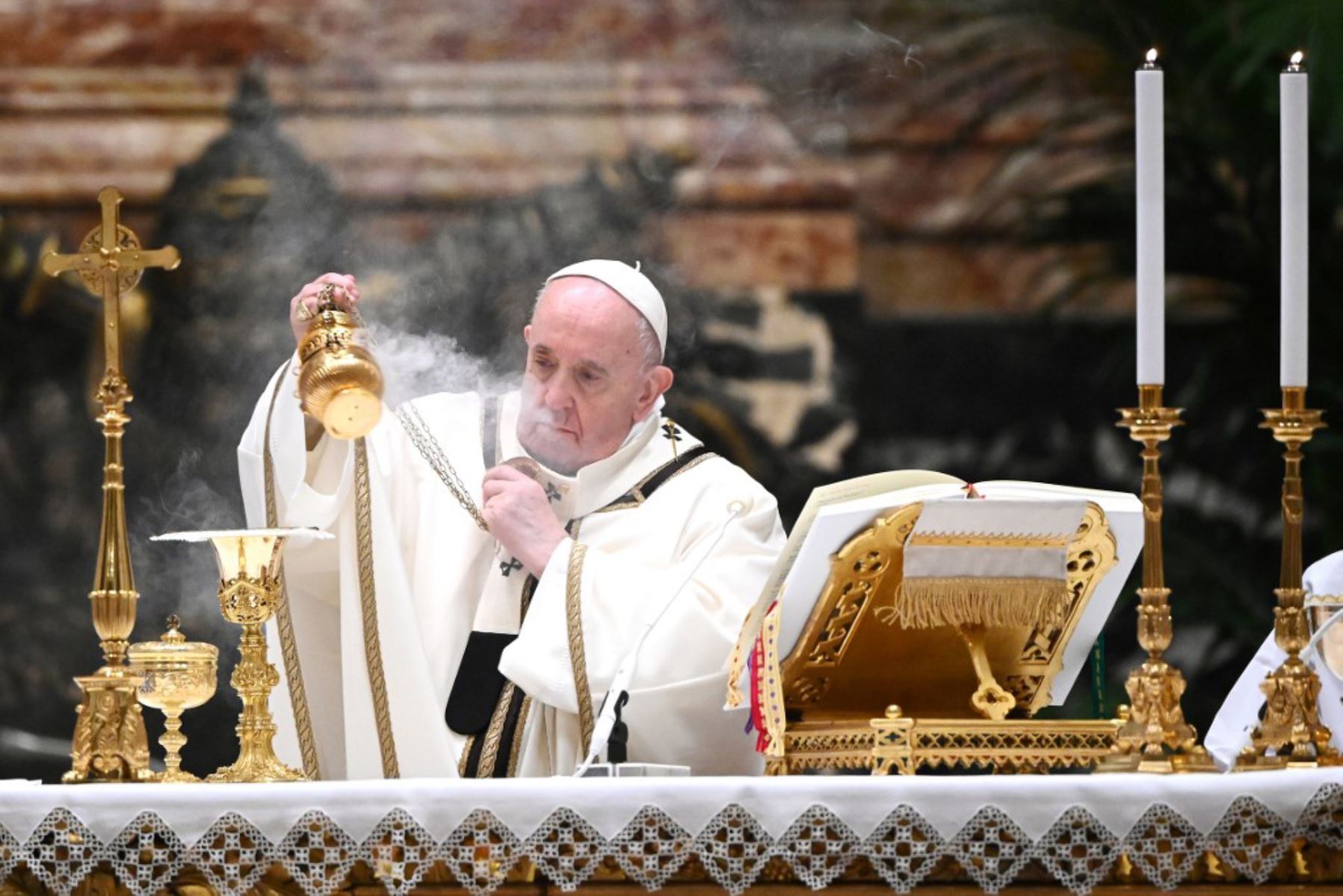 El Papa Francisco sostiene una hostia mientras lleva a cabo el rito de la comunión durante una misa de Nochebuena para conmemorar la natividad de Jesucristo, en la basílica de San Pedro en el Vaticano. Foto: AFP