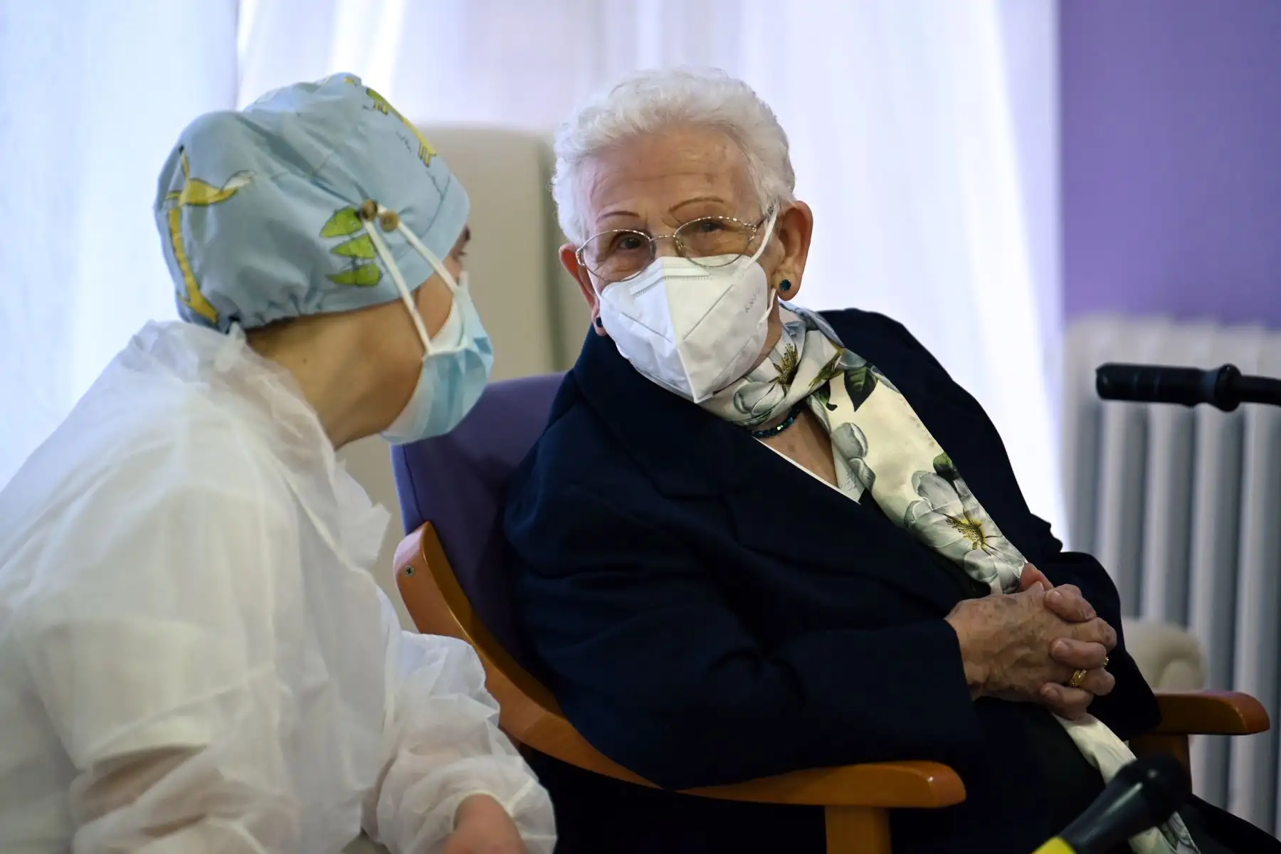 La cuidadora Mónica Tapias, de 48 años, conversa con Araceli Hidalgo, de 96 años, residente del asilo de ancianos Los Olmos, después de recibir una dosis de Pfizer, en España. Foto: AFP