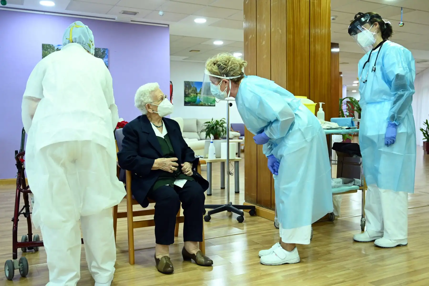 Araceli Hidalgo, de 96 años, residente del asilo de ancianos Los Olmos, habla con enfermeras antes de recibir una dosis de Pfizer-BioNTech Covid-19. Foto: AFP