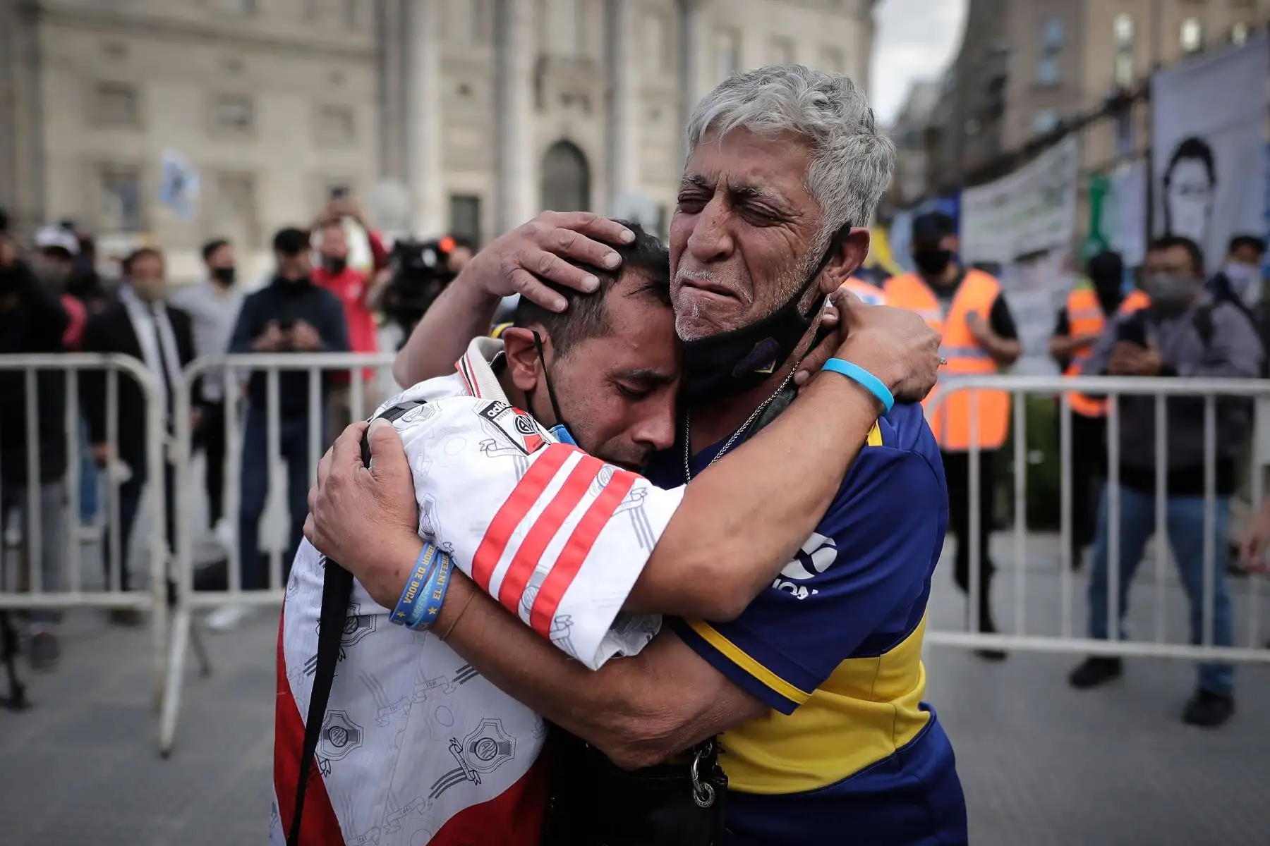 Un aficionado con la camiseta del Boca Juniors y otro con la camiseta del River Plate, se abrazan luego de despedir los restos de Diego Armando Maradona. Foto: EFE
