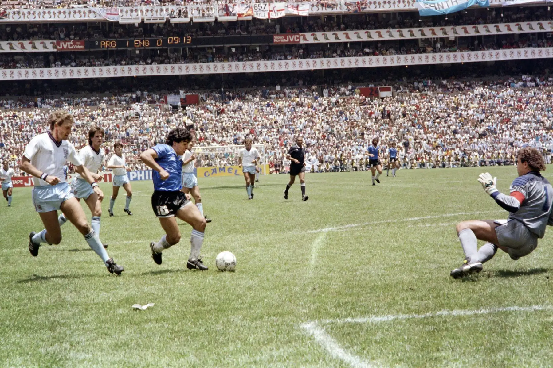 El delantero argentino Diego Armando Maradona pasa por delante del defensor inglés Terry Butcher en su camino hacia el portero Peter Shilton y anota su segundo gol, o gol del siglo, durante el partido de cuartos de final de la Copa del Mundo entre Argentina e Inglaterra el 22 de junio de 1986, en la Ciudad de México. Foto: AFP