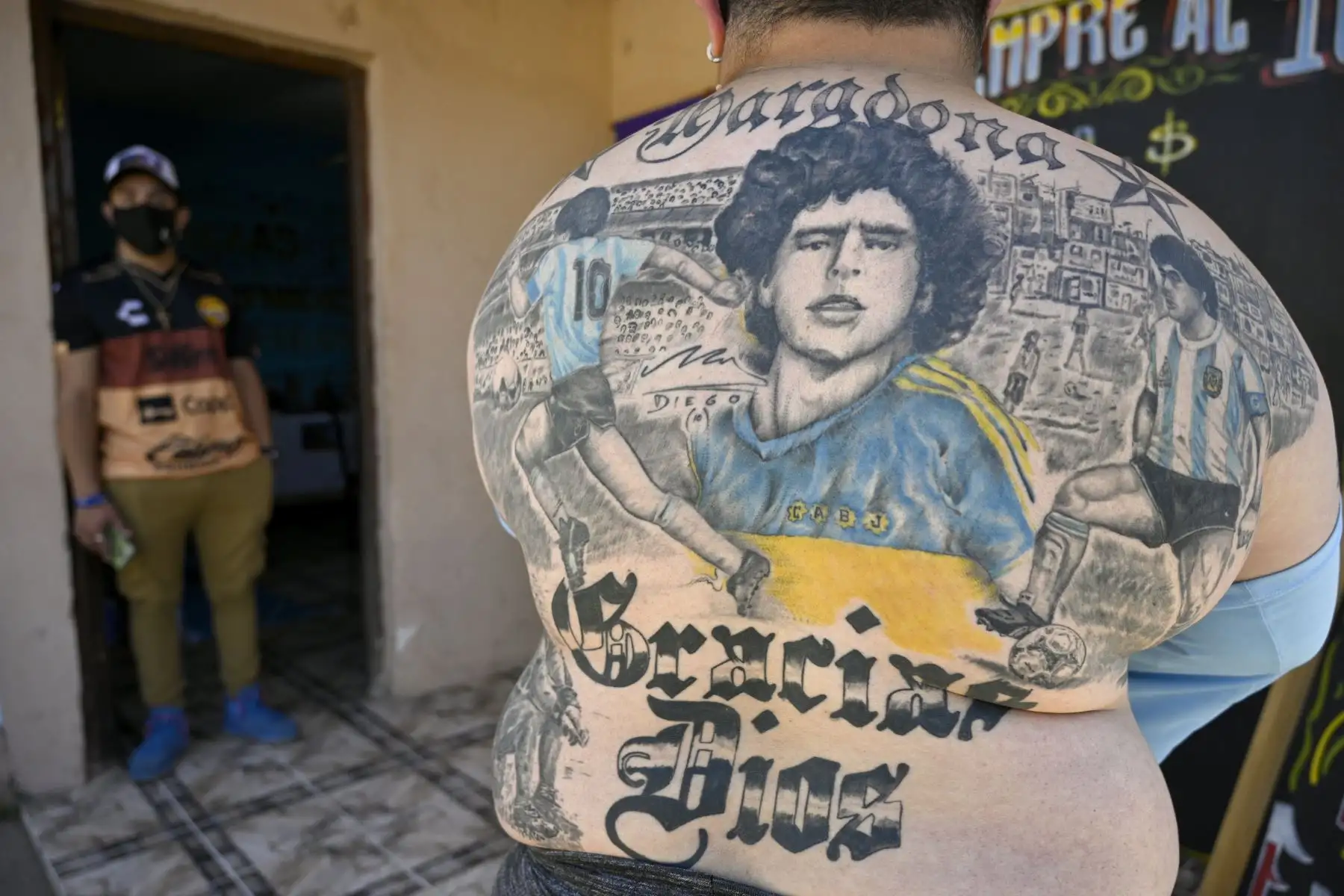 El pizzero Guillermo Rodríguez, bautizado en la iglesia de Maradonian, muestra los tatuajes en su espalda que representan a la leyenda del fútbol argentino Diego Maradona  en su pizzería llamada "Siempre al 10" en Merlo, provincia de Buenos Aires. Foto: AFP