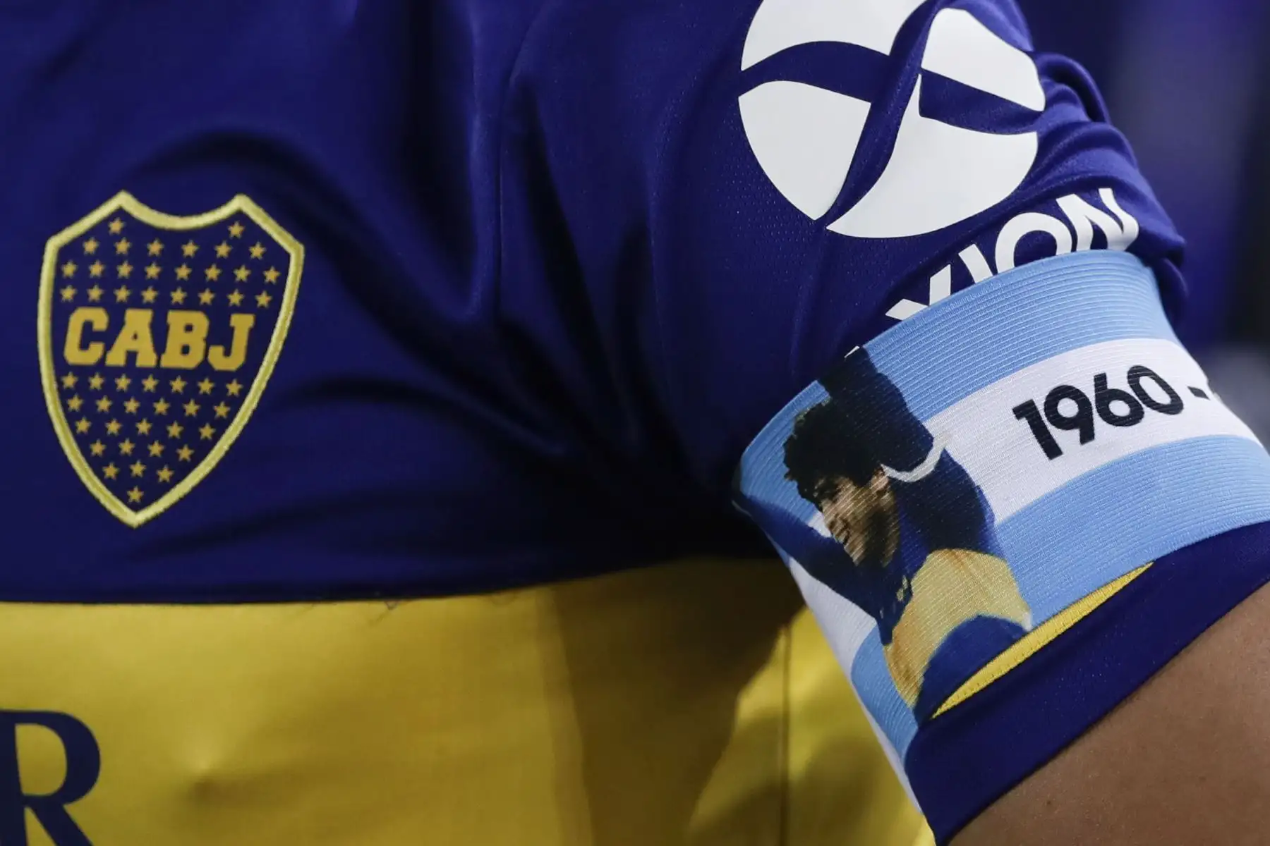 El argentino Boca Juniors Carlos Tevez usa un brazalete de bandera nacional con una imagen de la leyenda del fútbol argentino Diego Maradona, durante el partido de fútbol de cuartos de final de la Copa Libertadores contra el Racing Club en el Estadio Presidente Perón, en Avellaneda. Foto: AFP