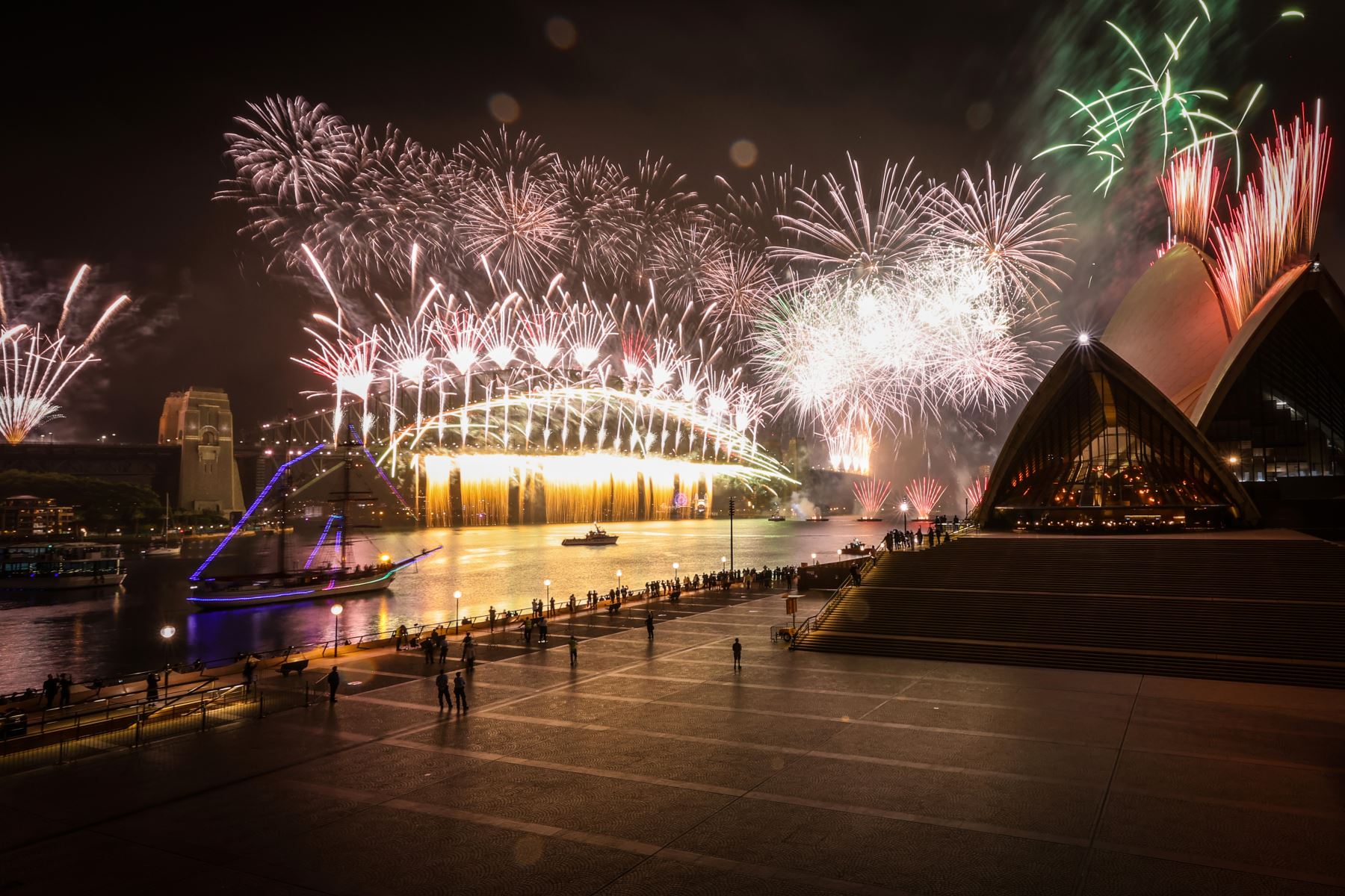 Una explanada desierta de la ópera de Sídney mientras explotan los fuegos artificiales, durante las celebraciones de Año Nuevo en el centro de Sídney el 1 de enero de 2021. 
FOTO: ANDINA/AFP