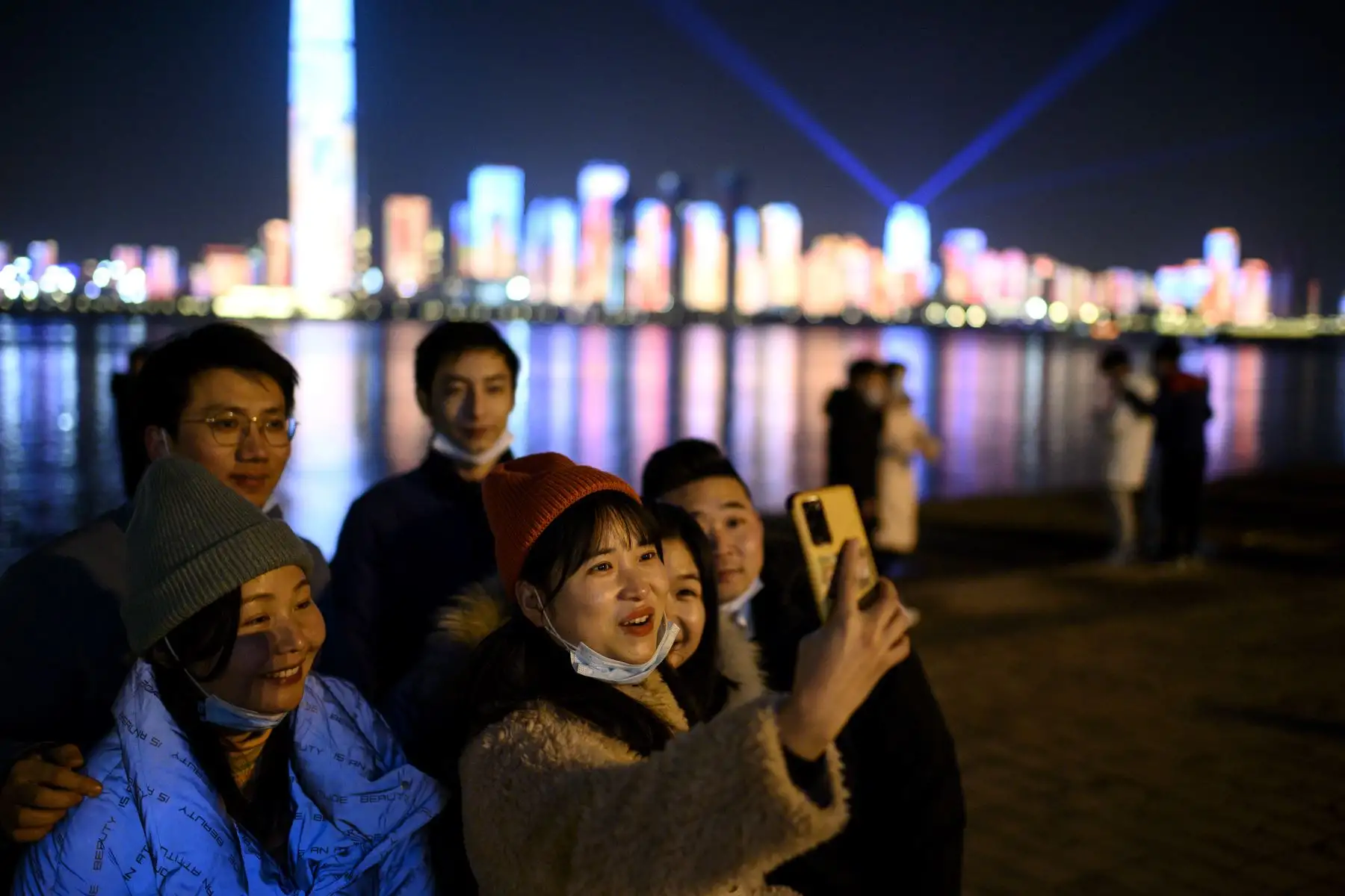 Las personas se bajan las máscaras faciales para tomarse una selfie antes de la cuenta regresiva de Año Nuevo en Wuhan, en la provincia central de Hubei, en China.
Foto: AFP