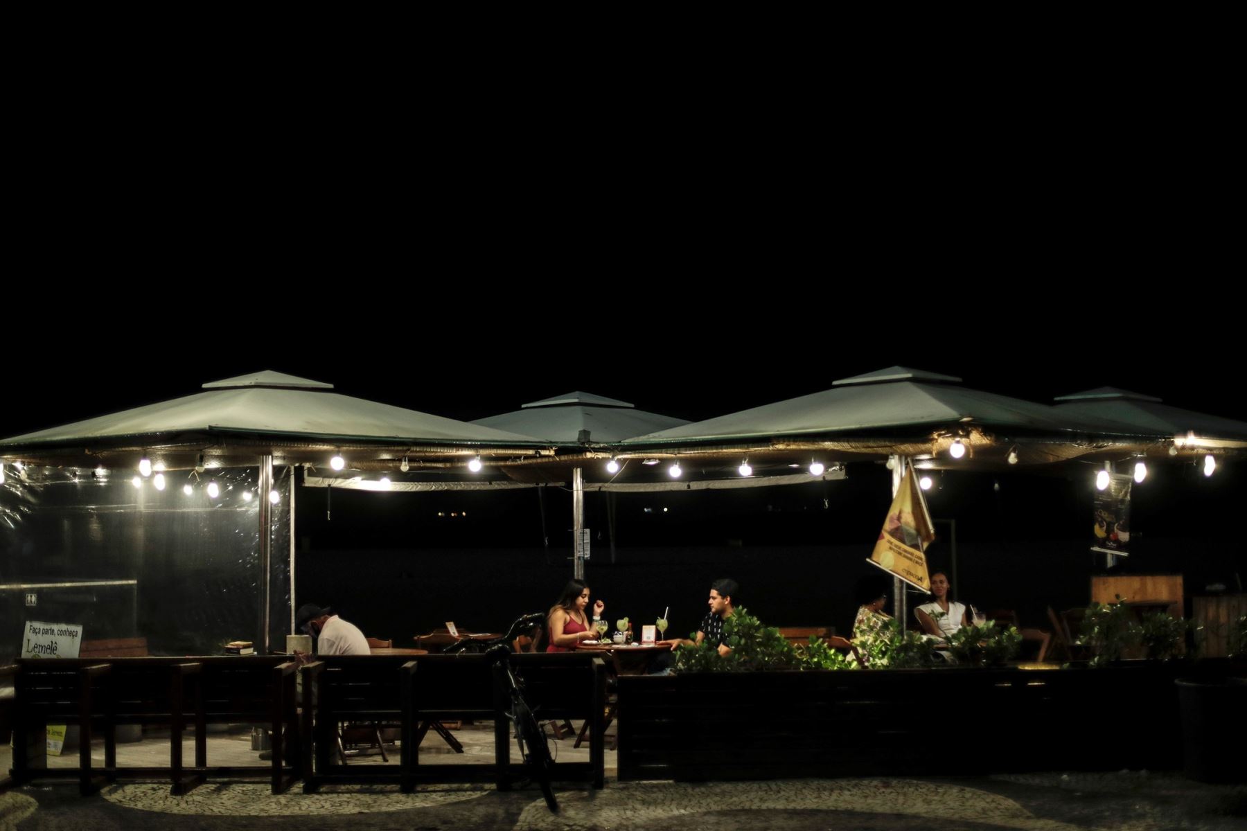 Una pareja cena en una tienda en la mítica playa de Copacabana hoy en Río de Janeiro (Brasil). Foto: EFE