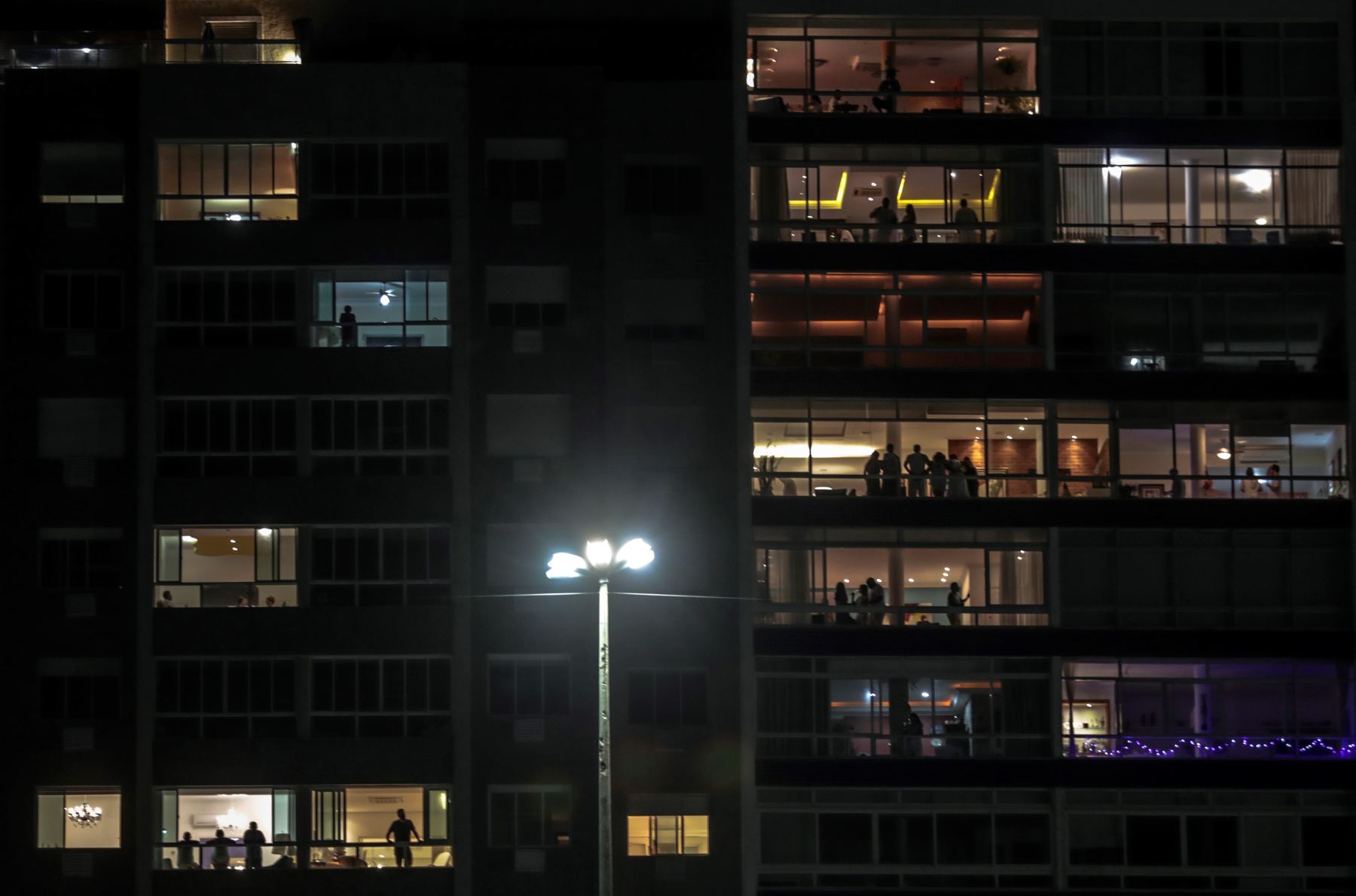 Varias personas de un edifico residencial de Copacabana se reúnen para las fiestas de fin de año enfrente la mítica playa de Copacabana. Foto: AFP