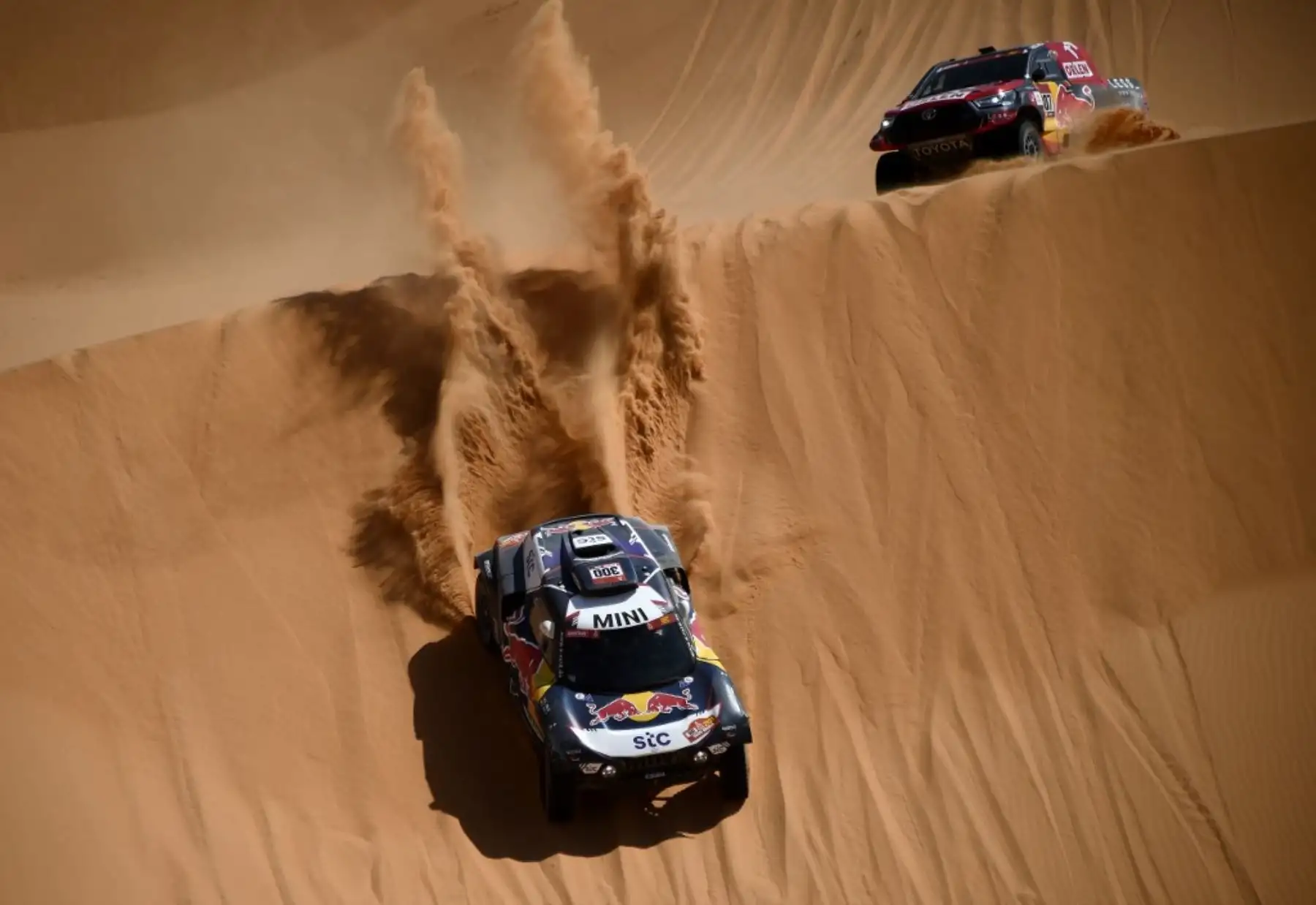 Los pilotos españoles de Mini Carlos Sainz de España y el copiloto Lucas Cruz de España, adelantan al piloto de Toyota Jakub Przygonski de Polonia y su copiloto Timo Gottschalk de Alemania compiten durante la Etapa 3 del Rally Dakar 2021. Foto: AFP