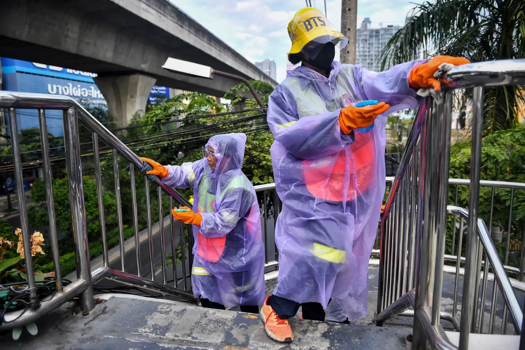 Los limpiadores de la Autoridad Metropolitana de Bangkok desinfectaron las barandillas de un puente peatonal en Bangkok, luego de que el gobierno impusiera más restricciones debido al reciente brote de coronavirus . Foto: AFP