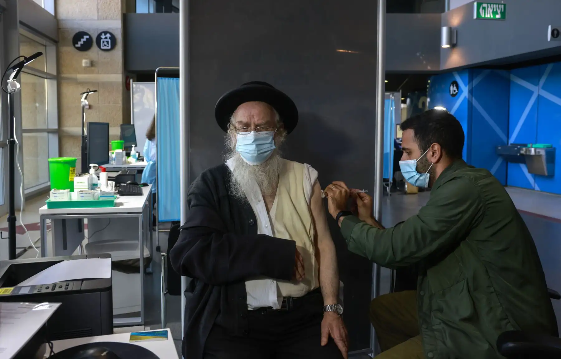 Un trabajador de la salud administra una vacuna COVID-19 a un judío ultraortodoxo en los Servicios de Salud Clalit de Israel en Jerusalén. Foto: AFP