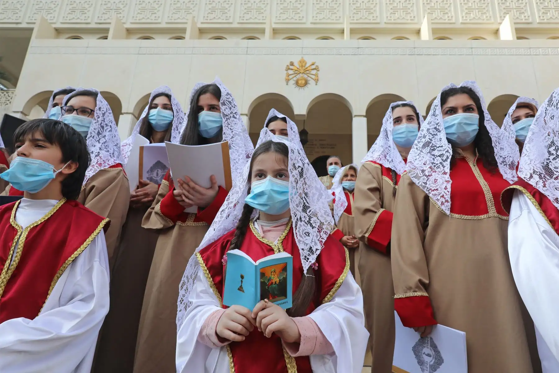 Los miembros de un coro, con máscaras protectoras debido a la pandemia de covid-19, cantan durante una misa de Navidad para los ortodoxos armenios en la ciudad libanesa de Antelias, al norte de Beirut. Foto. AFP