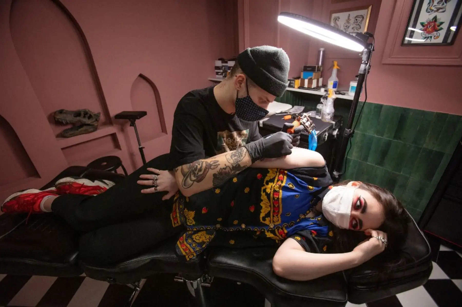 Un tatuador trabaja con un cliente en el salón de tatuajes Heartbreak Social Club en Irlanda. Foto: AFP