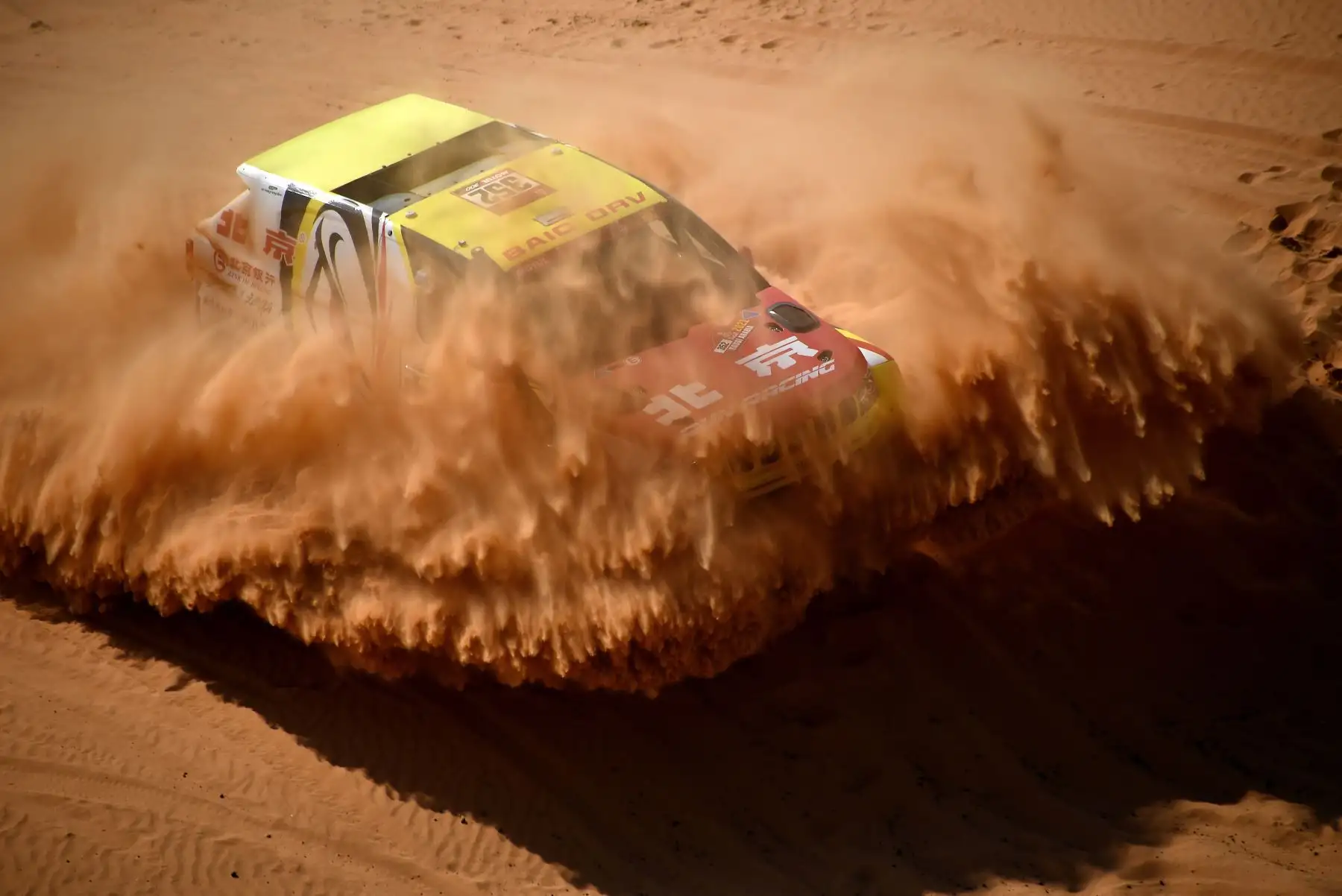 El piloto chino Guoyu Zhang y su copiloto He Sha compiten durante la sexta etapa del Rally Dakar 2021 entre Buraydah y Hail, en Arabia Saudita. Foto: AFP