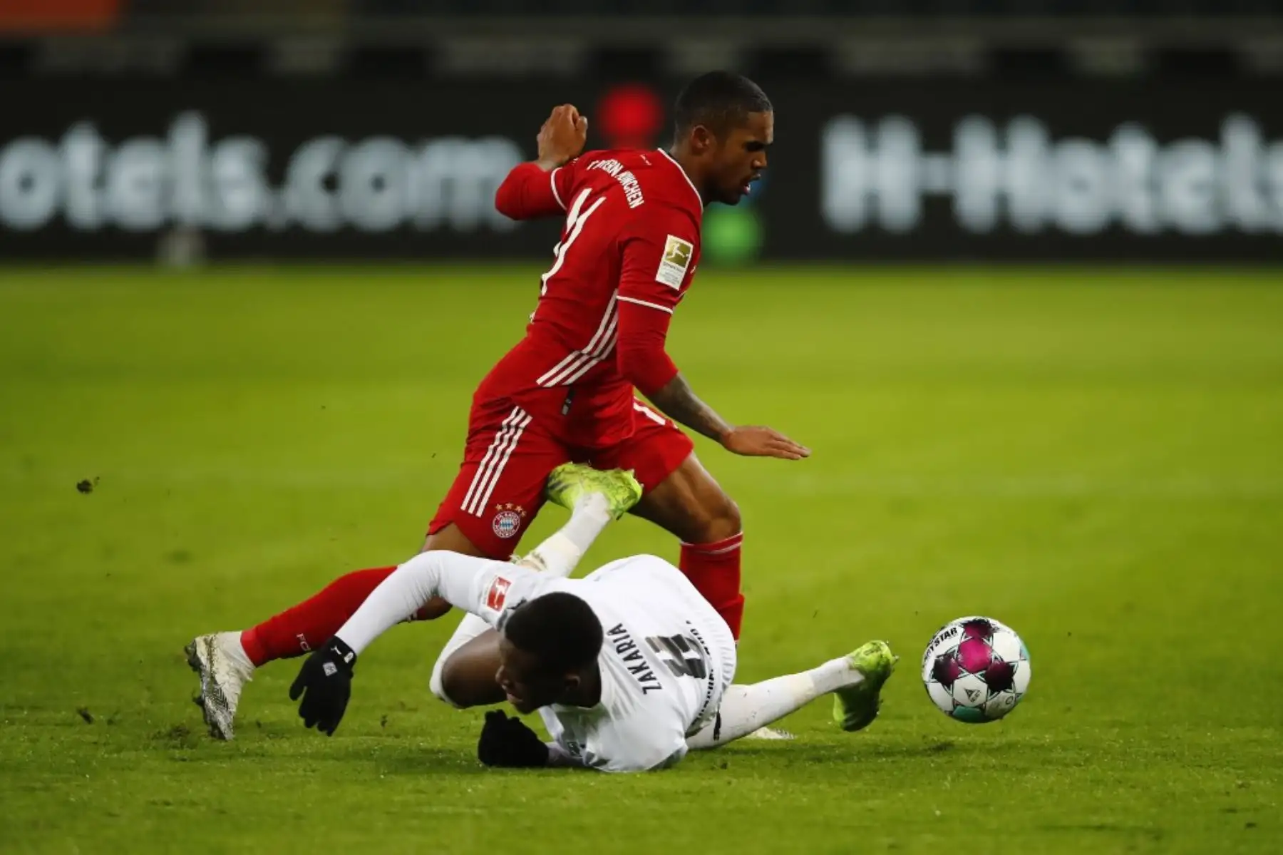 El centrocampista brasileño del Bayern Munich Douglas Costa y el centrocampista suizo de Moenchengladbach Denis Zakaria compiten por el balón durante el partido de fútbol de la Bundesliga de primera división alemana Borussia Moenchengladbach v FC Bayern Munich en Moenchengladbach, Alemania occidental, el 8 de enero de 2021. Foto: AFP