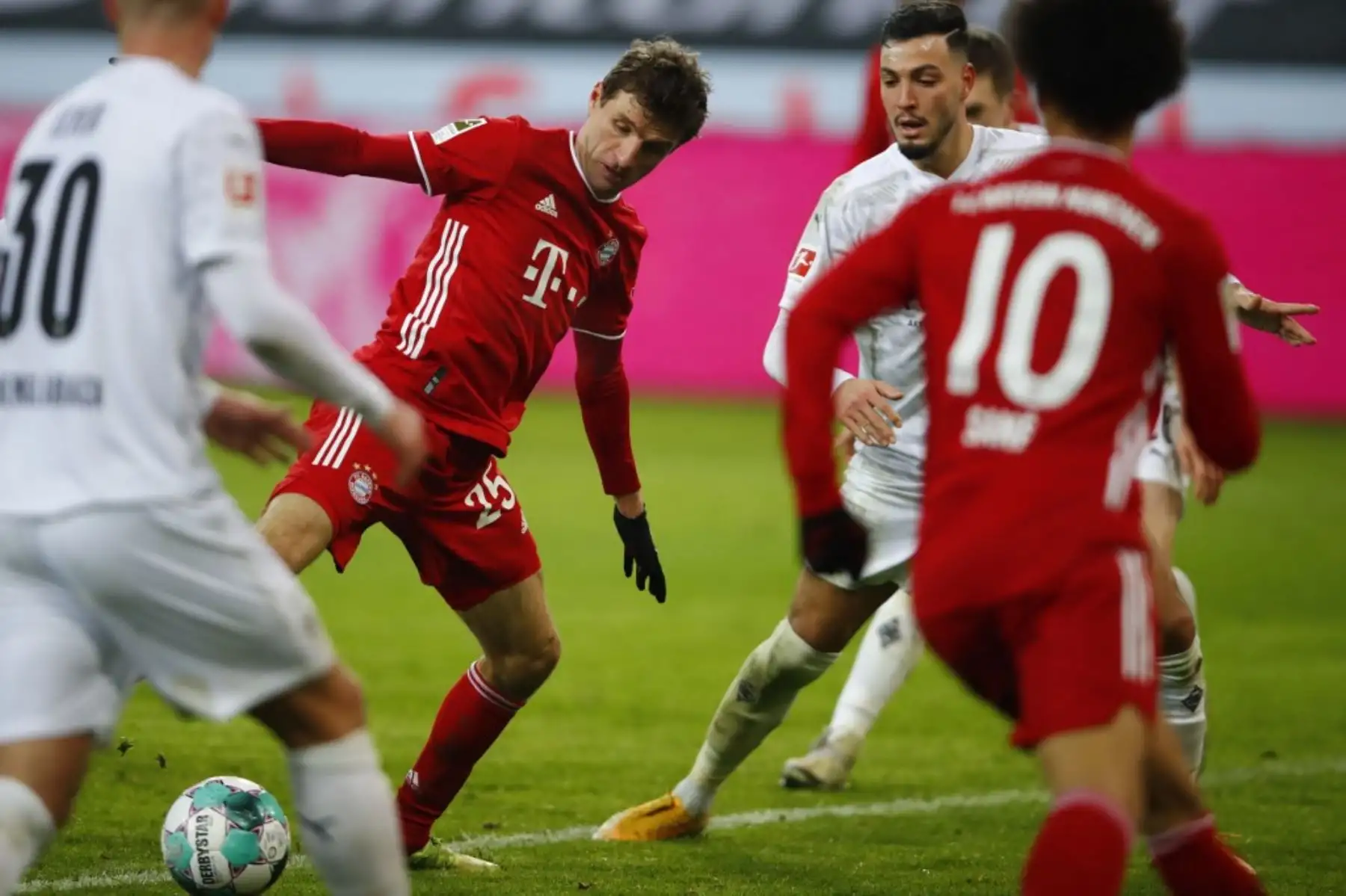 El delantero alemán del Bayern Munich Thomas Mueller (C) y el defensor argelino de Moenchengladbach Ramy Bensebaini (2ndR) compiten por el balón durante el partido de fútbol de la Bundesliga de primera división alemana Borussia Moenchengladbach v FC Bayern Munich en Moenchengladbach, Alemania occidental el 8 de enero de 2021. Foto: AFP