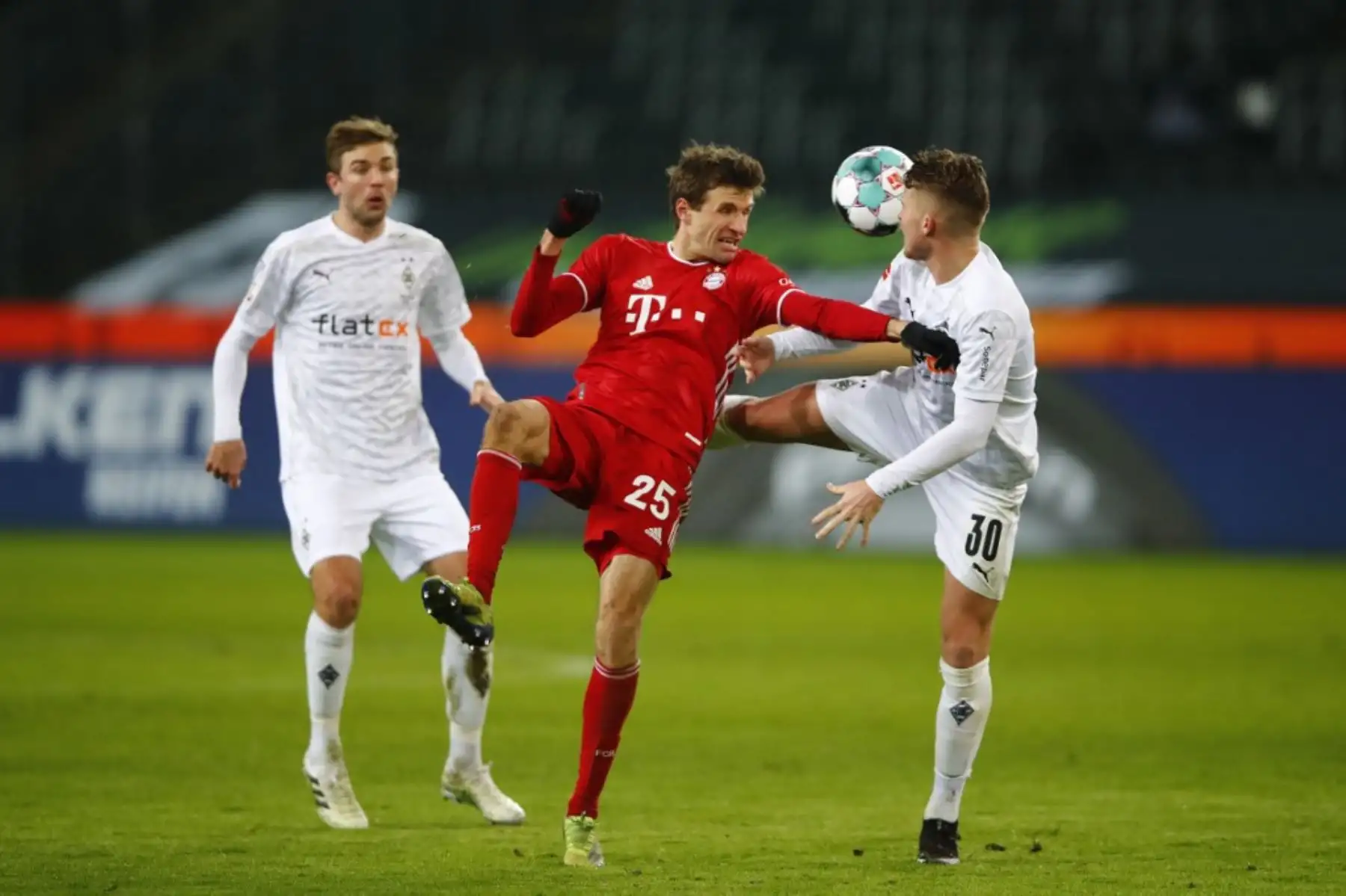 El delantero alemán del Bayern Munich Thomas Mueller (C) y el defensor suizo de Moenchengladbach Nico Elvedi (R) compiten por el balón durante el partido de fútbol de la Bundesliga de primera división alemana Borussia Moenchengladbach v FC Bayern Munich en Moenchengladbach, en el oeste de Alemania, el 8 de enero de 2021. Foto: AFP