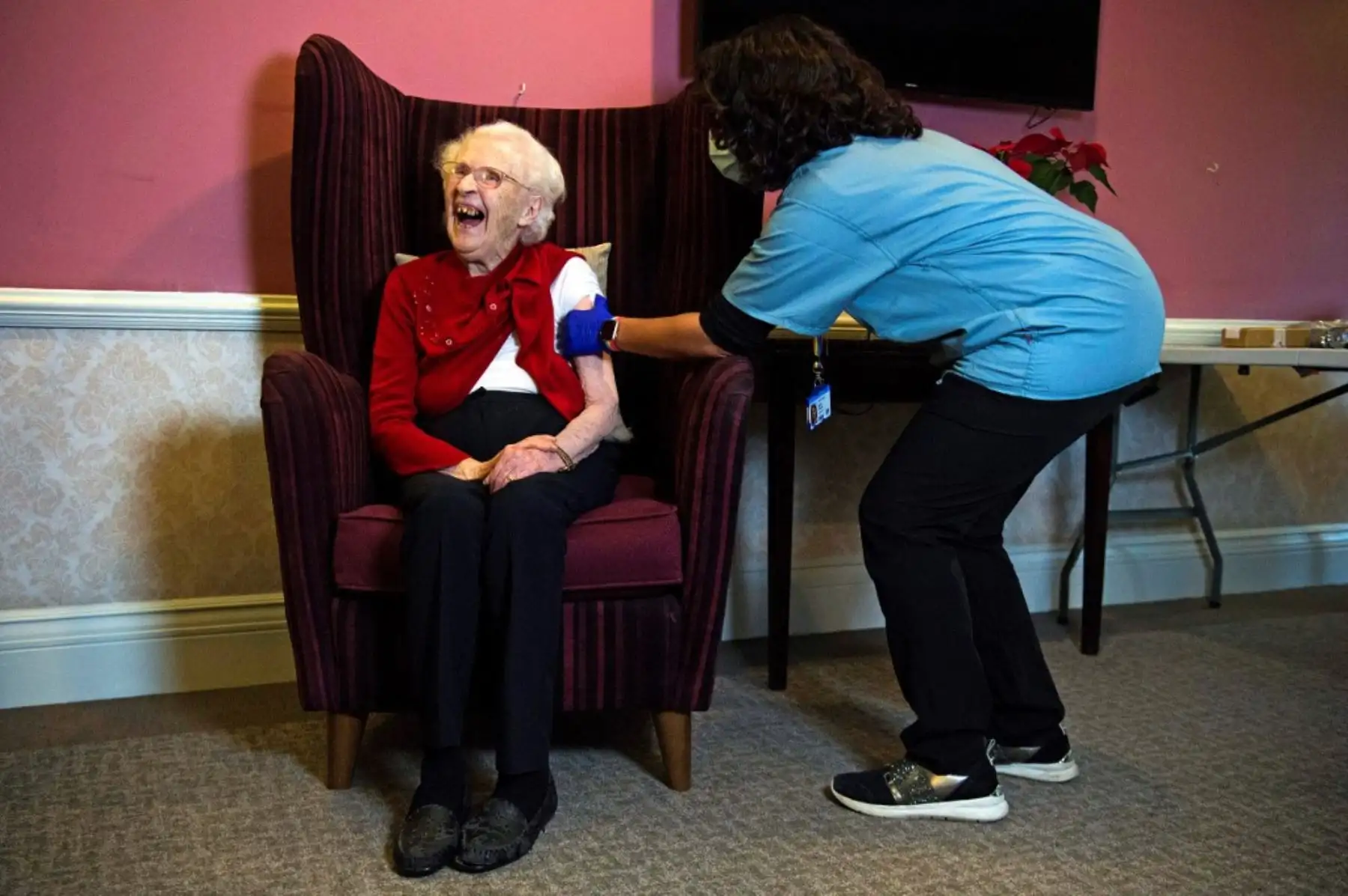 Ellen Prosser, de cien años, conocida como Nell, recibe la vacuna COVID-19 Oxford / AstraZeneca del Dr. Nikki Kanani en el Sunrise Care Home en Sidcup, al sureste de Londres. Foto: AFP