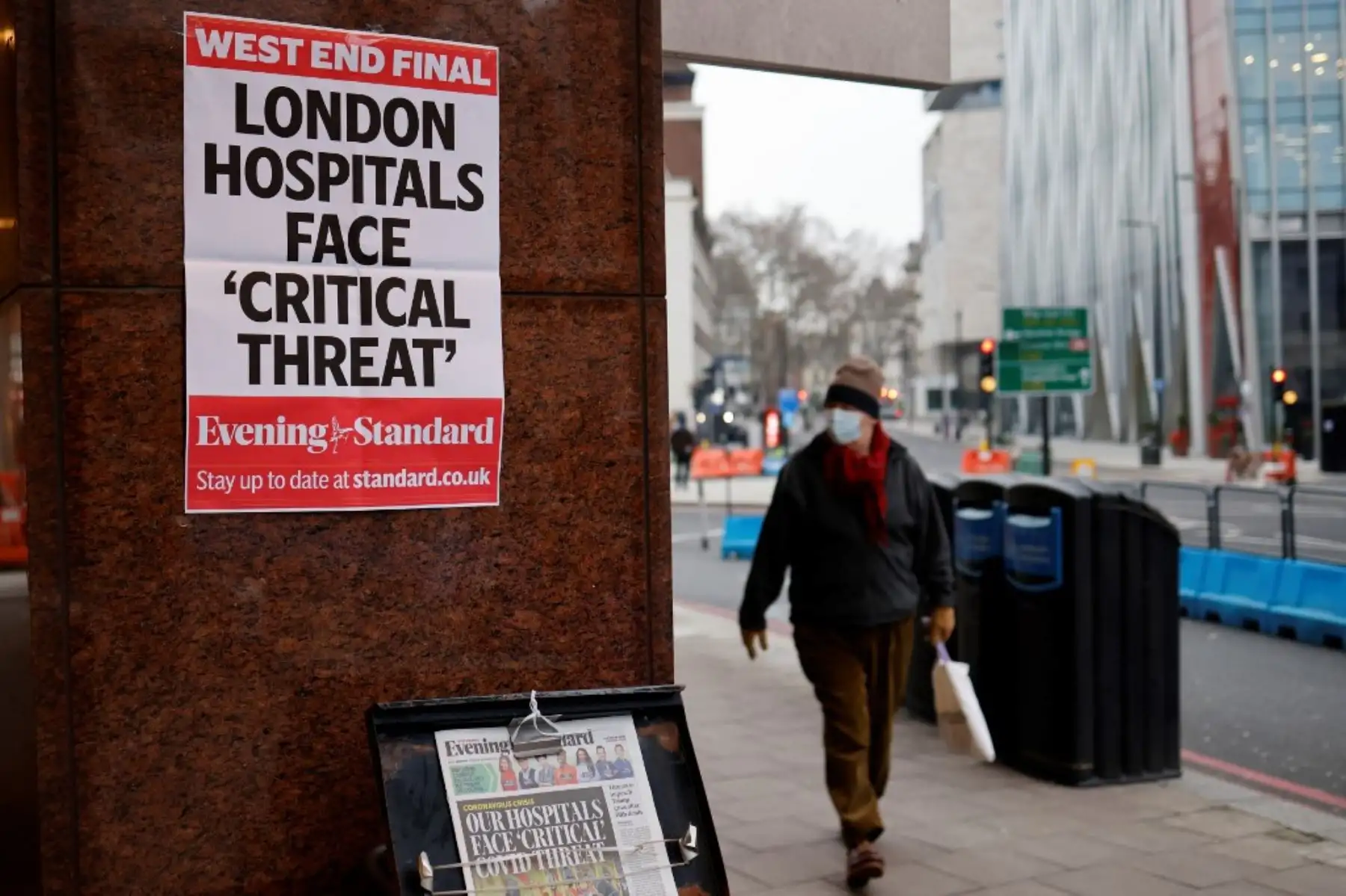 Un peatón con una mascarilla pasa frente a un puesto de los periódicos Evening Standard en el centro de Londres el 8 de enero de 2021. Foto: AFP