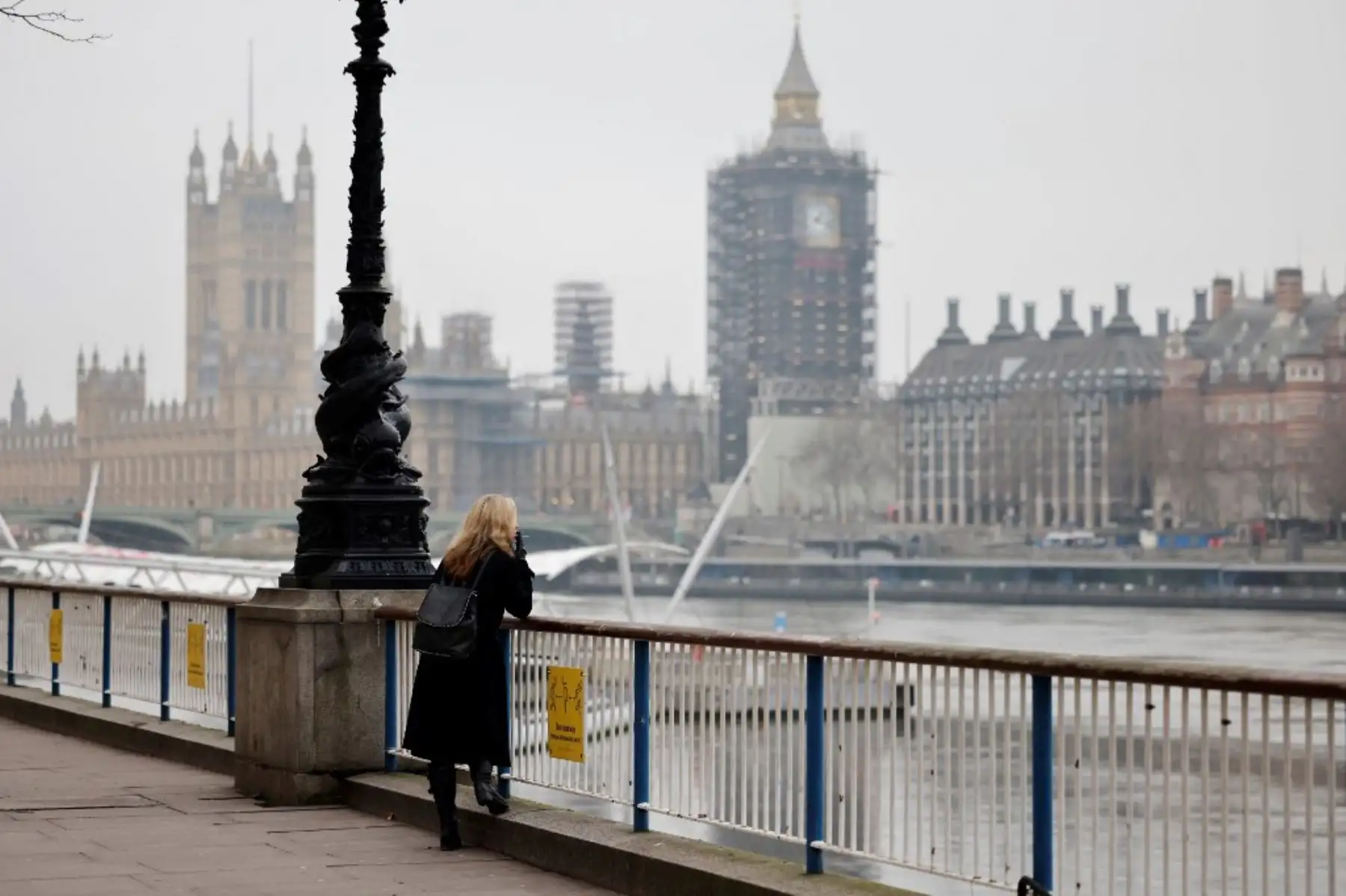 Una mujer fuma un cigarrillo mientras se apoya en una barandilla a lo largo del terraplén del río Támesis en el centro de Londres el 8 de enero de 2021, cuando Inglaterra entró en un tercer bloqueo debido al nuevo coronavirus covid-19. Foto: AFP