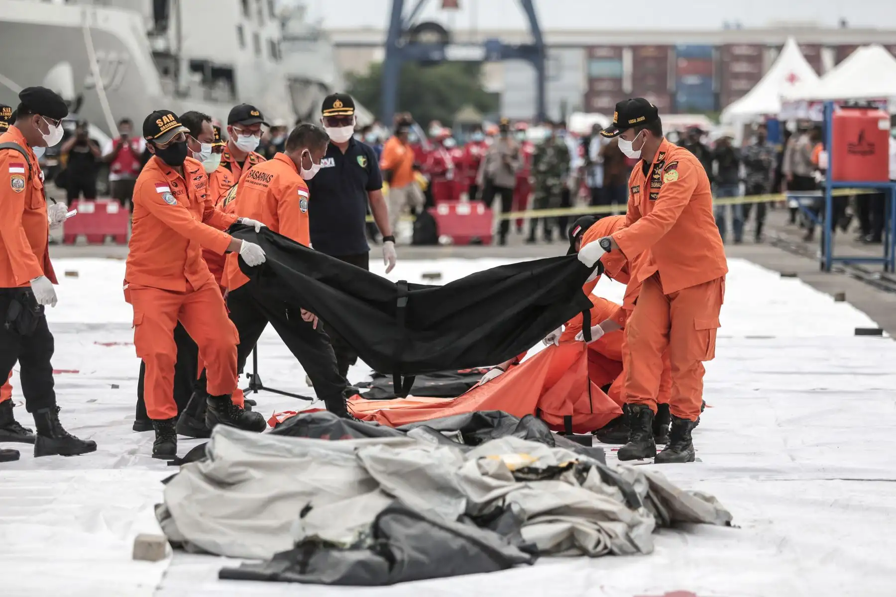 Los equipos de rescate colocan bolsas para cadáveres que contienen restos humanos recuperados del lugar del accidente del vuelo SJ182 de Sriwijaya Air en el puerto de Yakarta , luego del accidente del avión Boeing 737-500 de la aerolínea en el mar de Java minutos después del despegue.
Foto: AFP