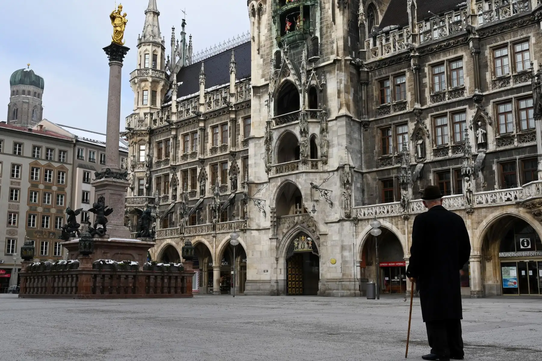 Un hombre vestido de negro con un bastón y un sombrero se encuentra en la plaza Marienplatz vacía frente al ayuntamiento en el centro de la ciudad de Múnich, en el sur de Alemania, en medio de la pandemia del nuevo coronavirus Covid-19 en curso. Foto: AFP