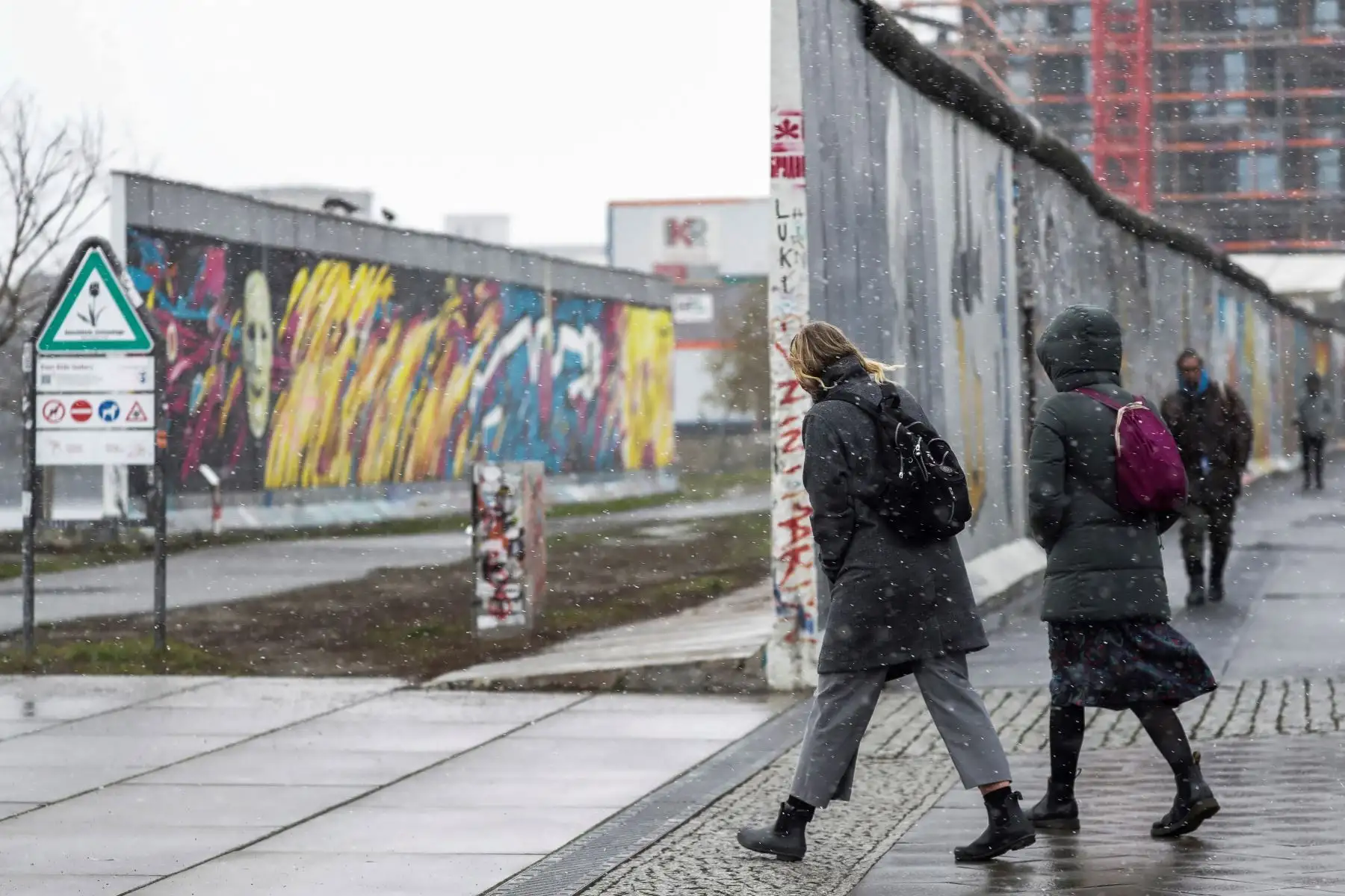 Personas caminan bajo la nieve a lo largo de la East Side Gallery en Berlín, Alemania. Restricción de viajes para los residentes en los 15 km de radio, entró en vigor a nivel nacional en Alemania para luchar contra una segunda ola de coronavirus. Foto: EFE