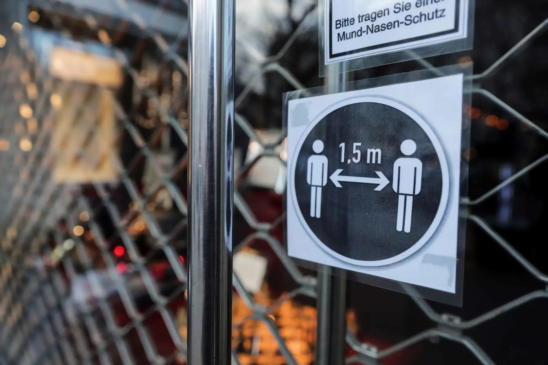 Un cartel, indica mantener una distancia de 1,5 metros en la puerta de entrada de una tienda cerrada en Berlín, Alemania. Foto: EFE