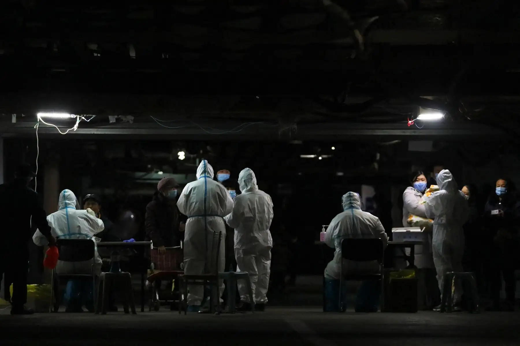 Los residentes se someten a pruebas de Covid-19 en el sótano de un complejo residencial como parte de un programa de pruebas masivas tras los nuevos casos del virus que surgieron en Shijiazhuang, en la provincia de Hebei, en el centro de China, el 12 de enero de 2021. Foto: AFP