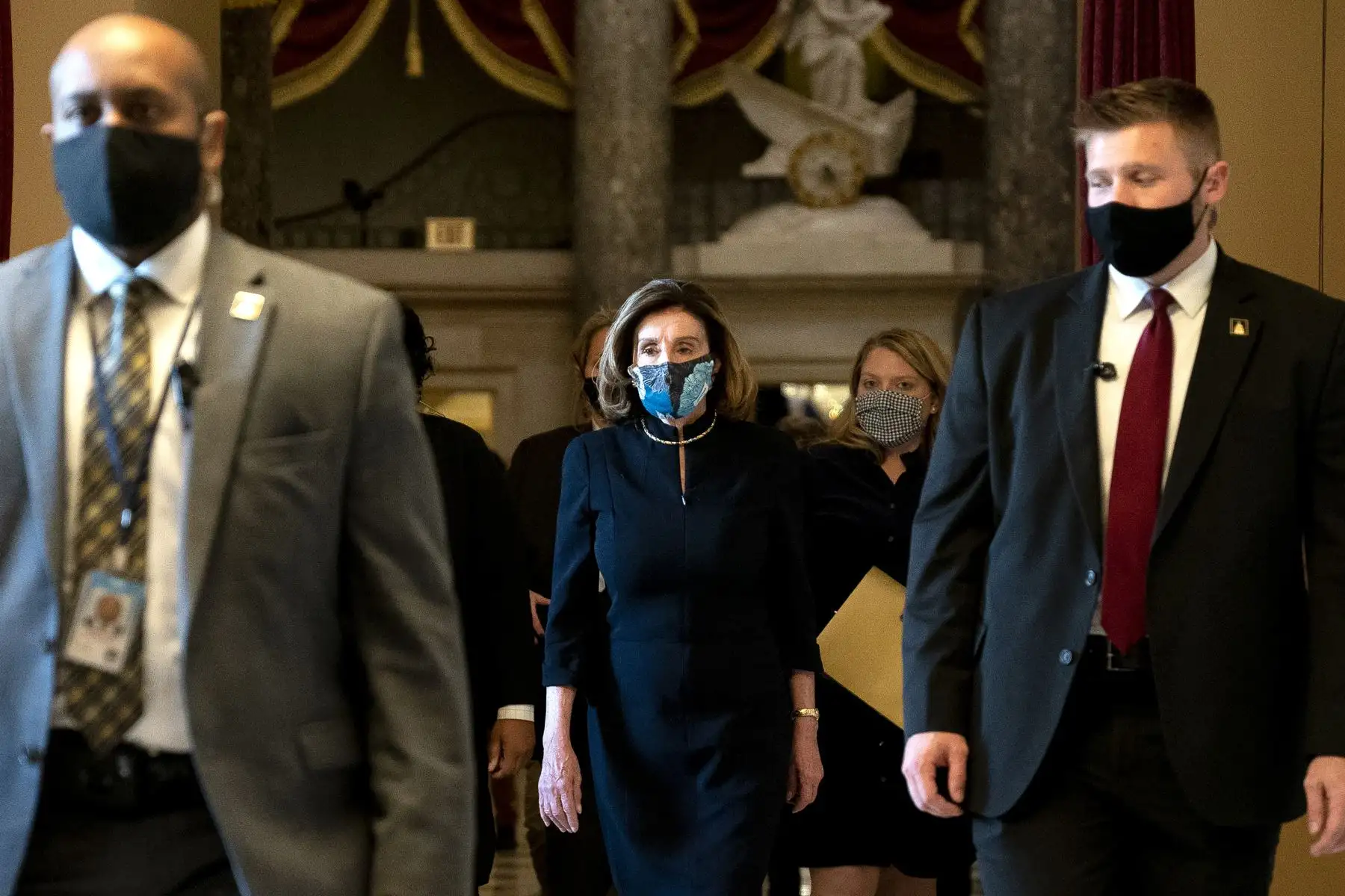 La presidenta de la Cámara de Representantes, Nancy Pelosi, usa una máscara protectora mientras camina hacia el piso de la Cámara durante una votación sobre la acusación del presidente Donald Trump en el Capitolio de los Estados Unidos
Foto: AFP